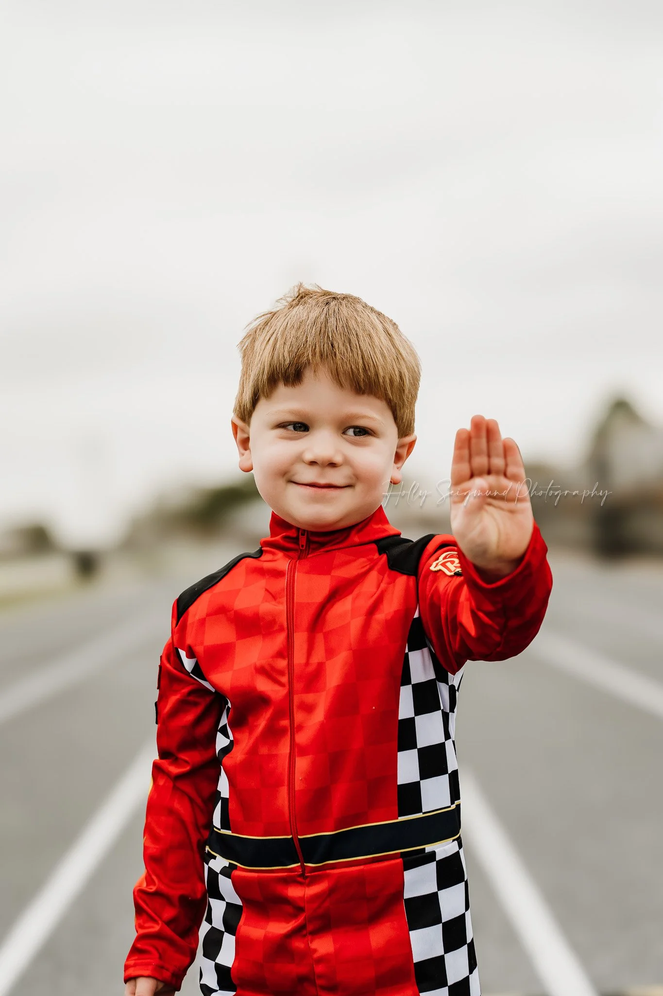 young boy enjoying a racing themed birthday photoshoot in Giddings Texas