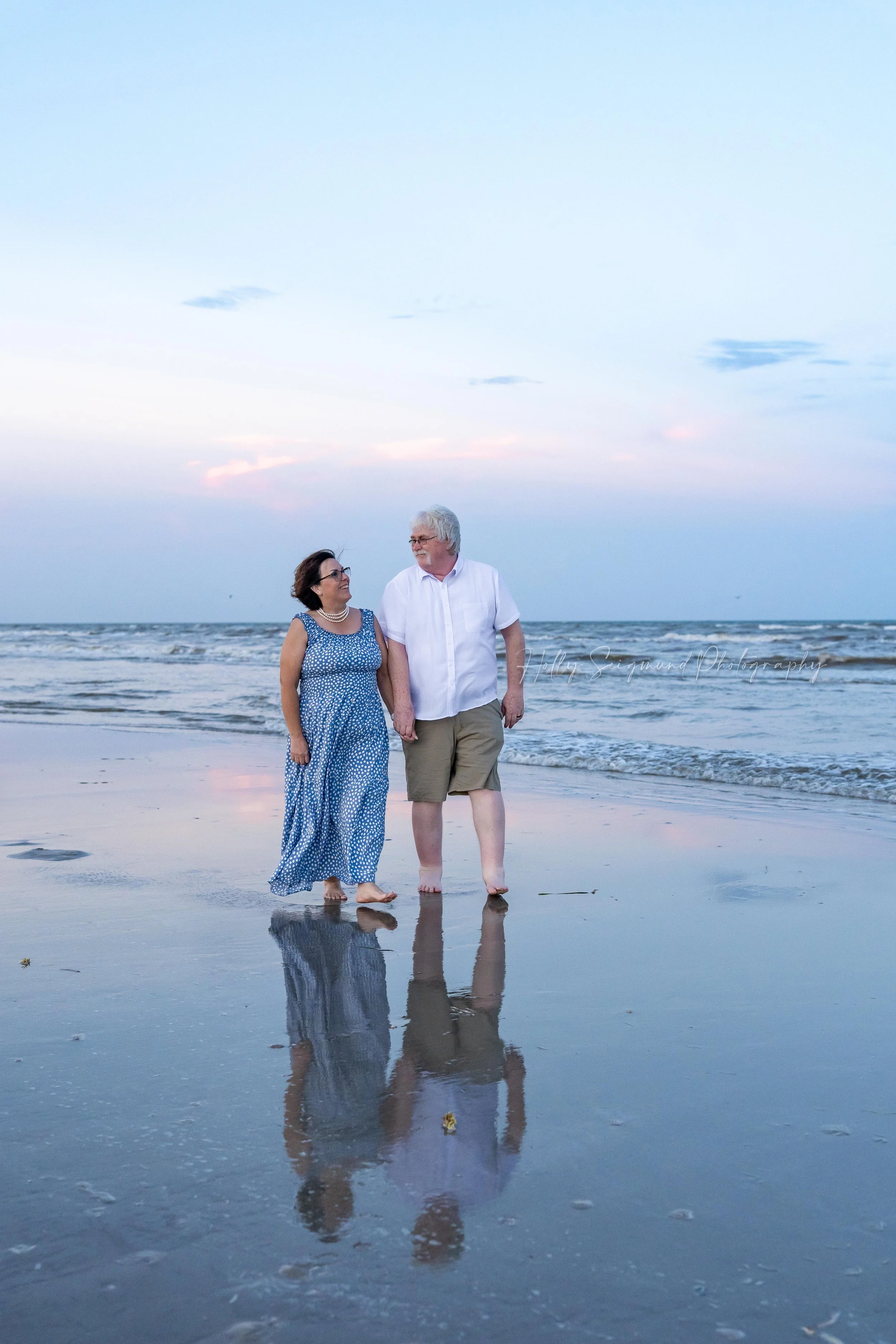 Couple walking on the beach with a reflection during Beach Mini Sessions in Port Aransas, Texas