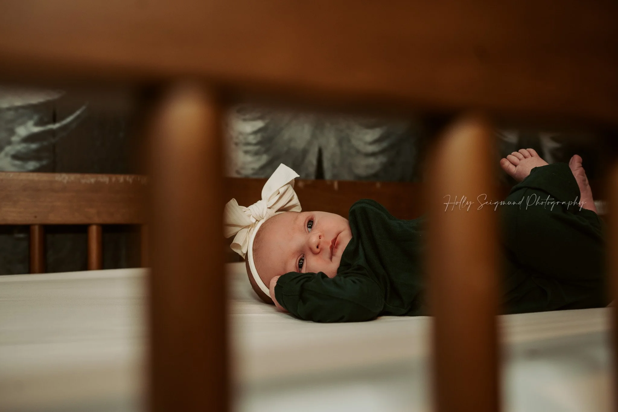 Newborn girl in baby crib during a lifestyle newborn session in Central Texas