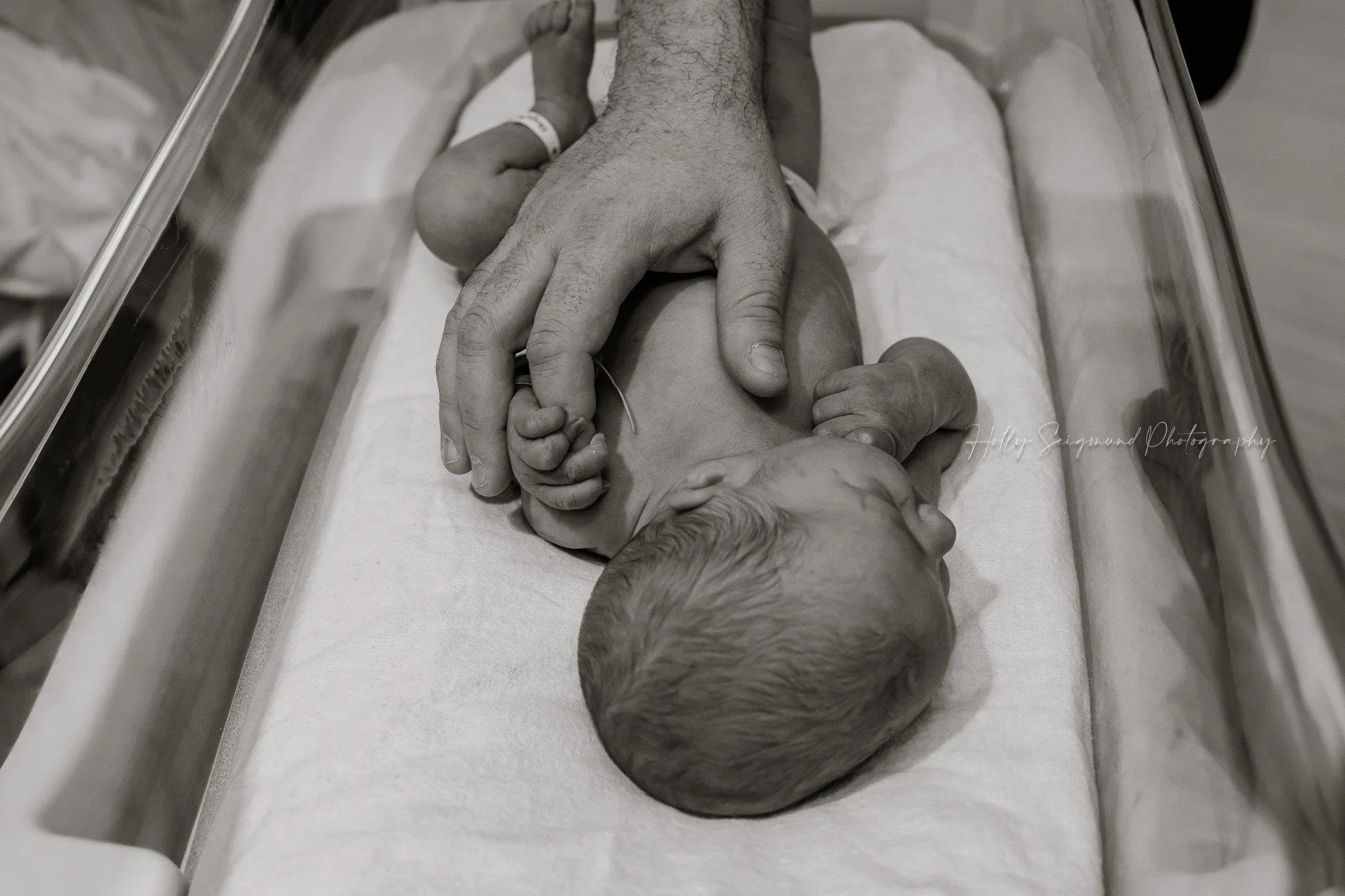 Newborn baby resting in hospital crib during Fresh 48 session in Austin, TX