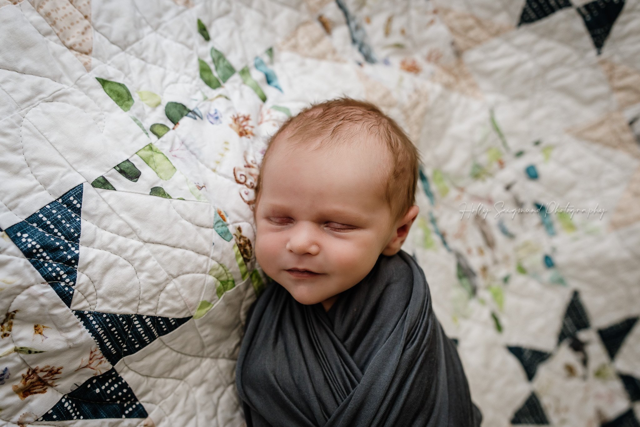 Newborn wrapped in blue on a vintage quilt in Central Texas