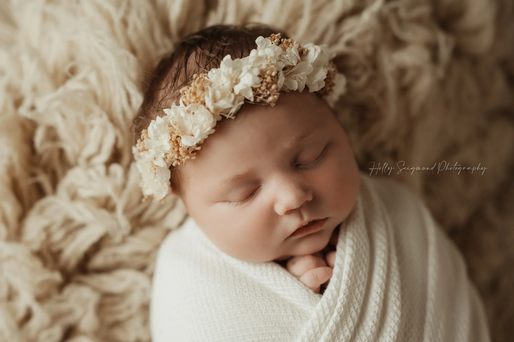 Cream floral crown on a newborn baby laying on a Suede Tan Flokati in Lee County photography studio