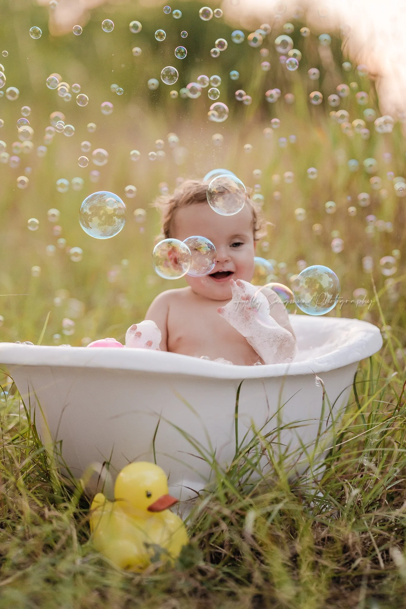 Baby clawfoot bathtub in the grass with bubbles in the air in Lee County Texas