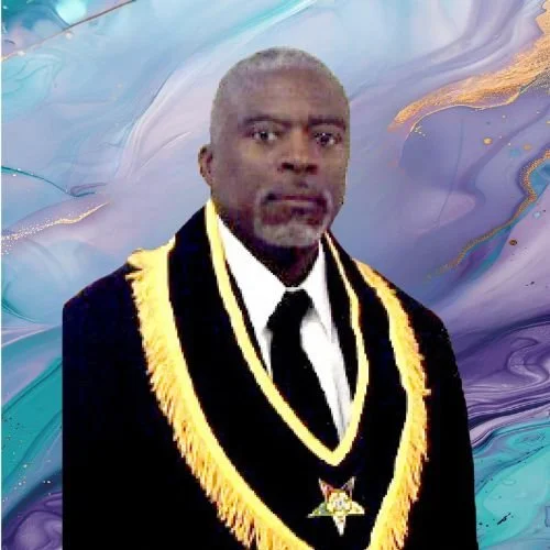 A man in a formal suit with a royal blue sash and gold fringe, standing in front of a colorful, abstract background.