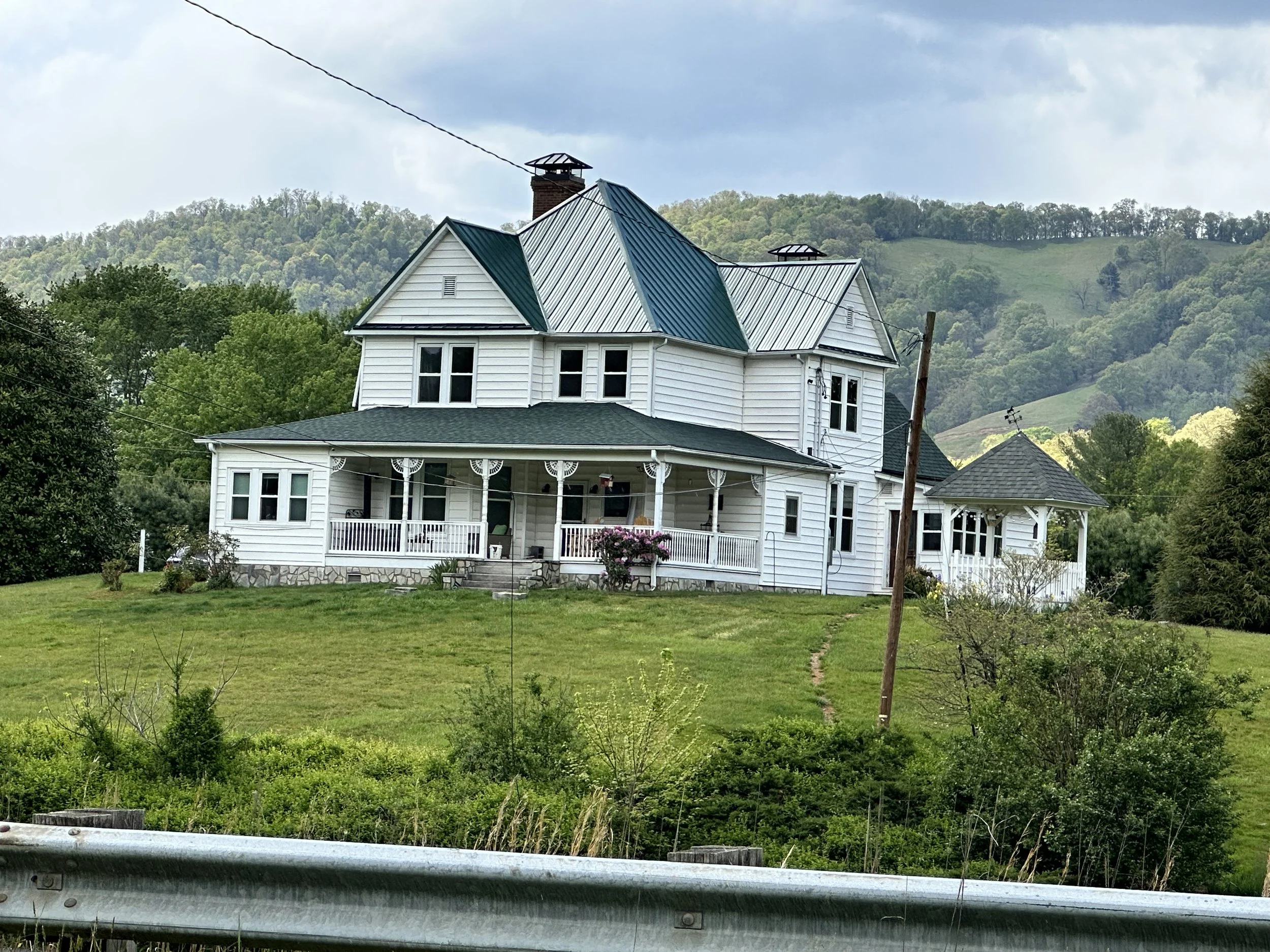 Construction workers installing metal roofing on a house under construction.