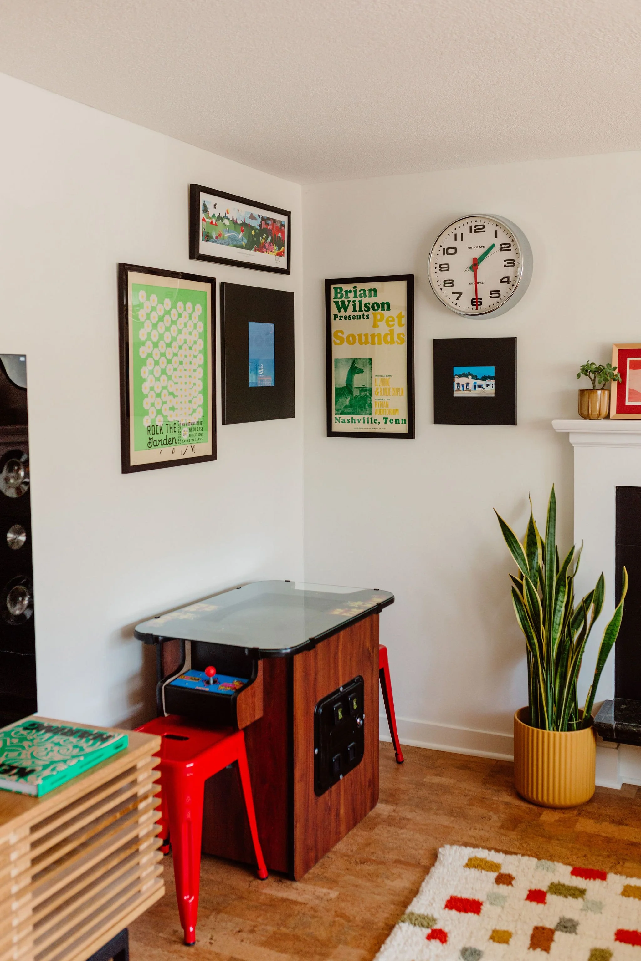 Gaming corner with Ms. Pacman and vibrant gallery wall.