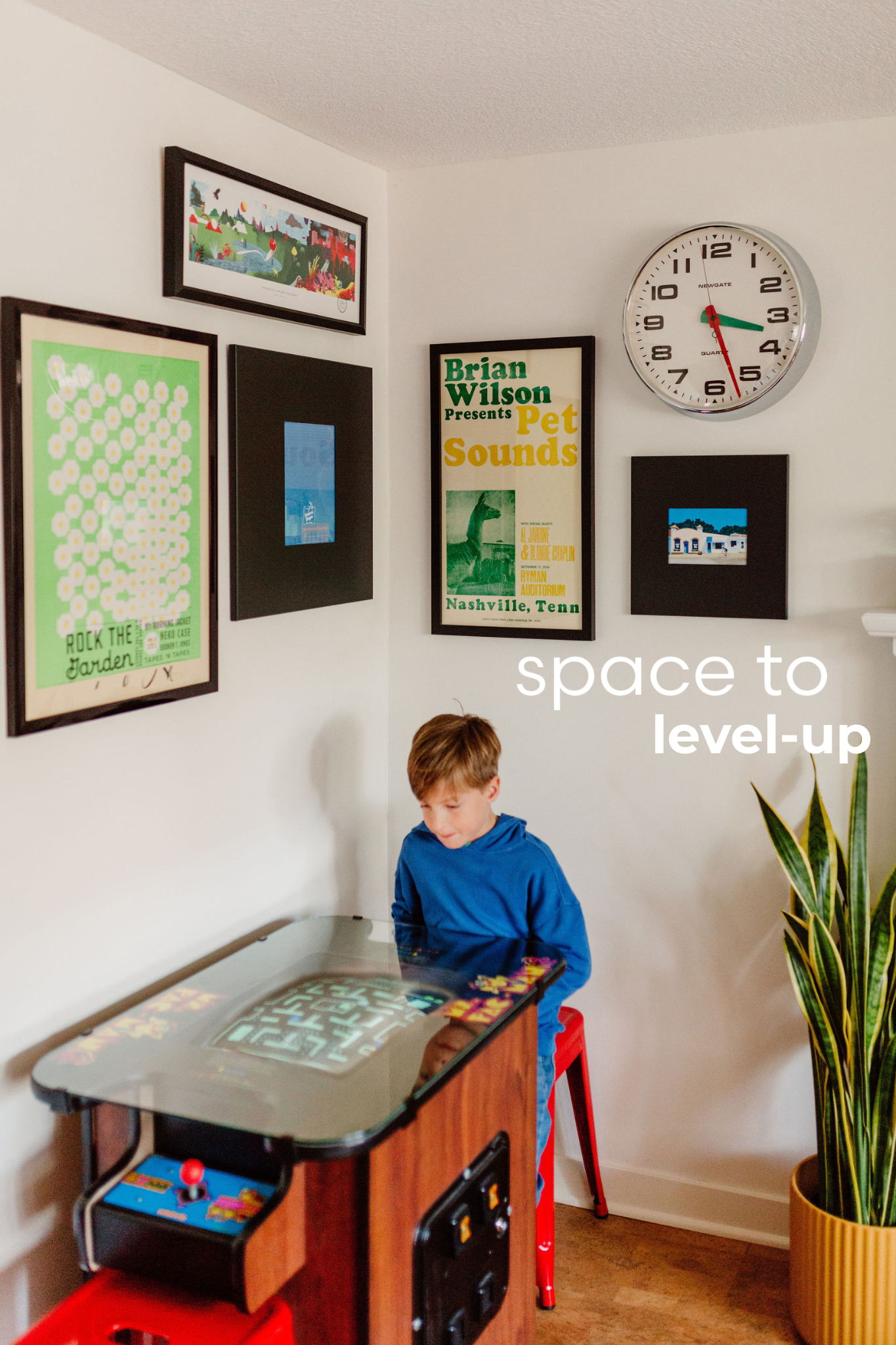 Gaming corner with Ms. Pacman and vibrant gallery wall.