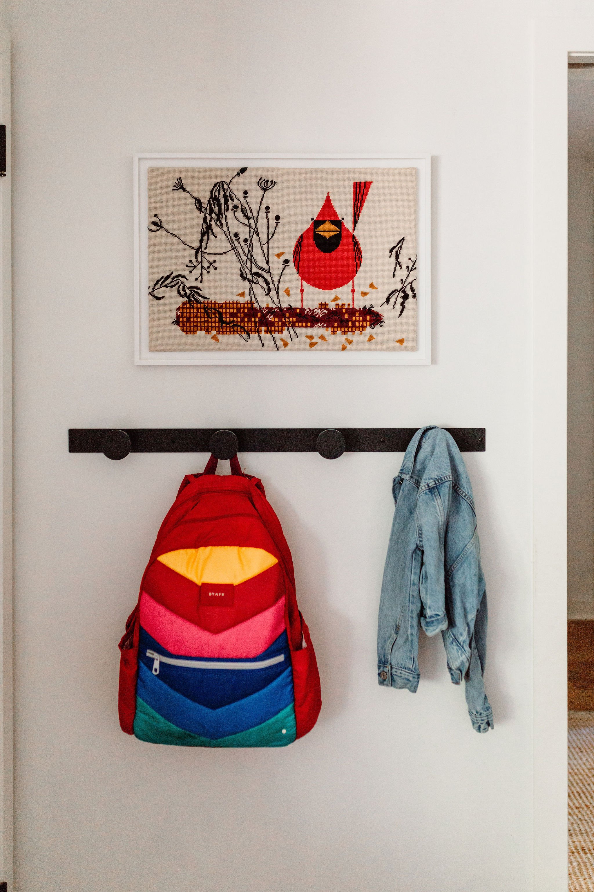 Minimalist entryway with accessible black hooks for coats and bags, creating a clutter-free welcome.