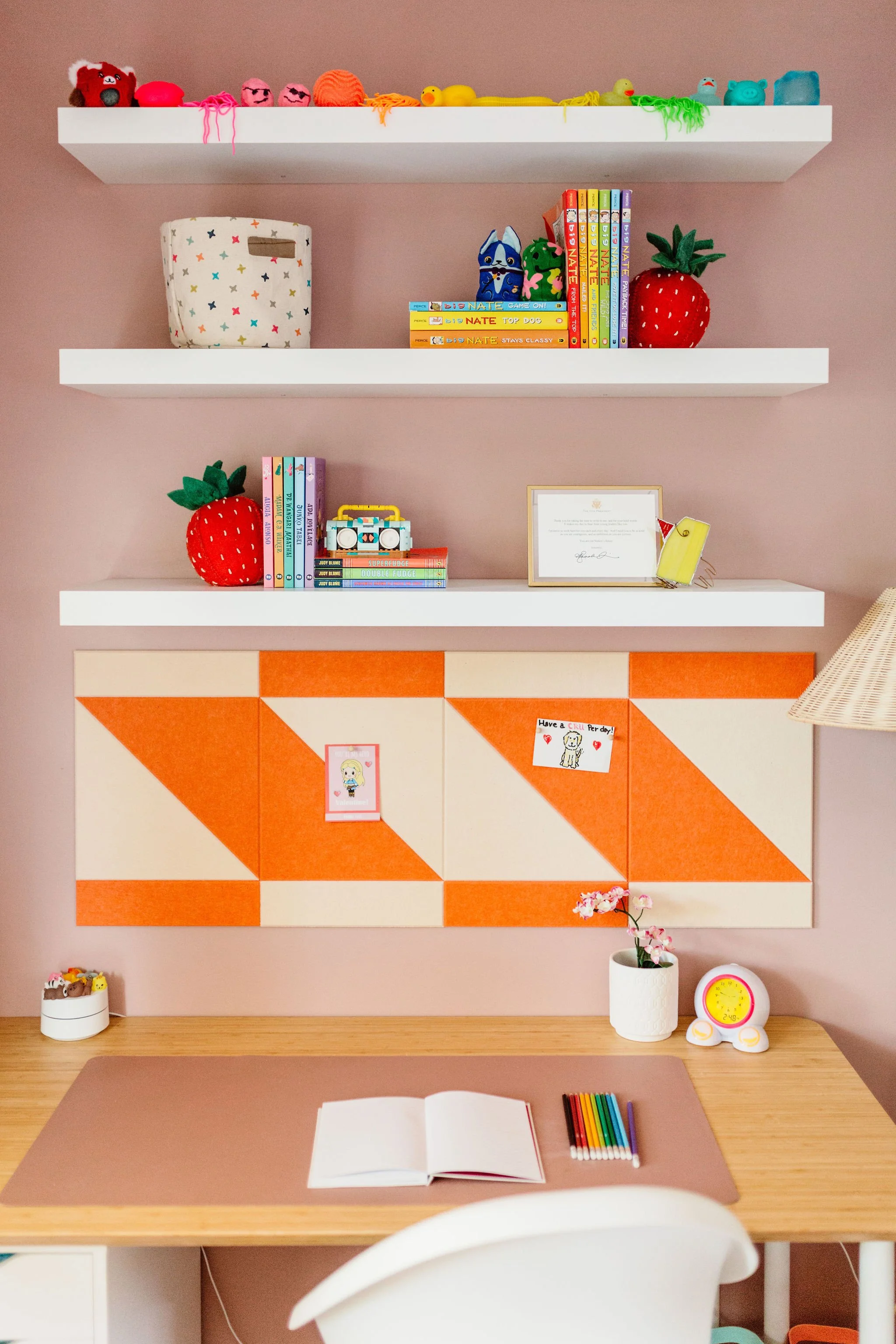Dreamy desk setup for creative girl with colorful felt board and wall shelves to display art, books and treasures.