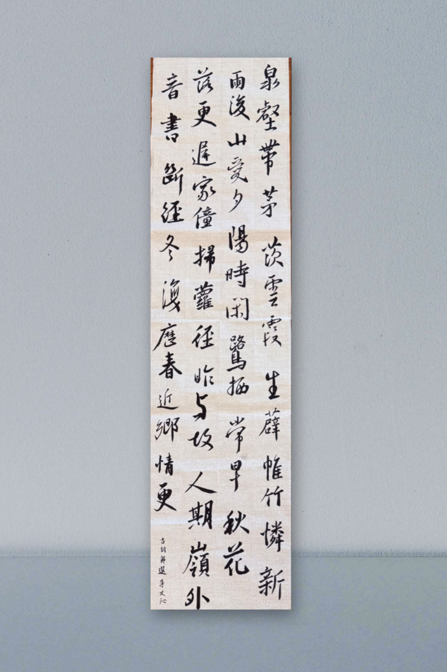 A vertical scroll of traditional Chinese calligraphy on paper, mounted on a wall.