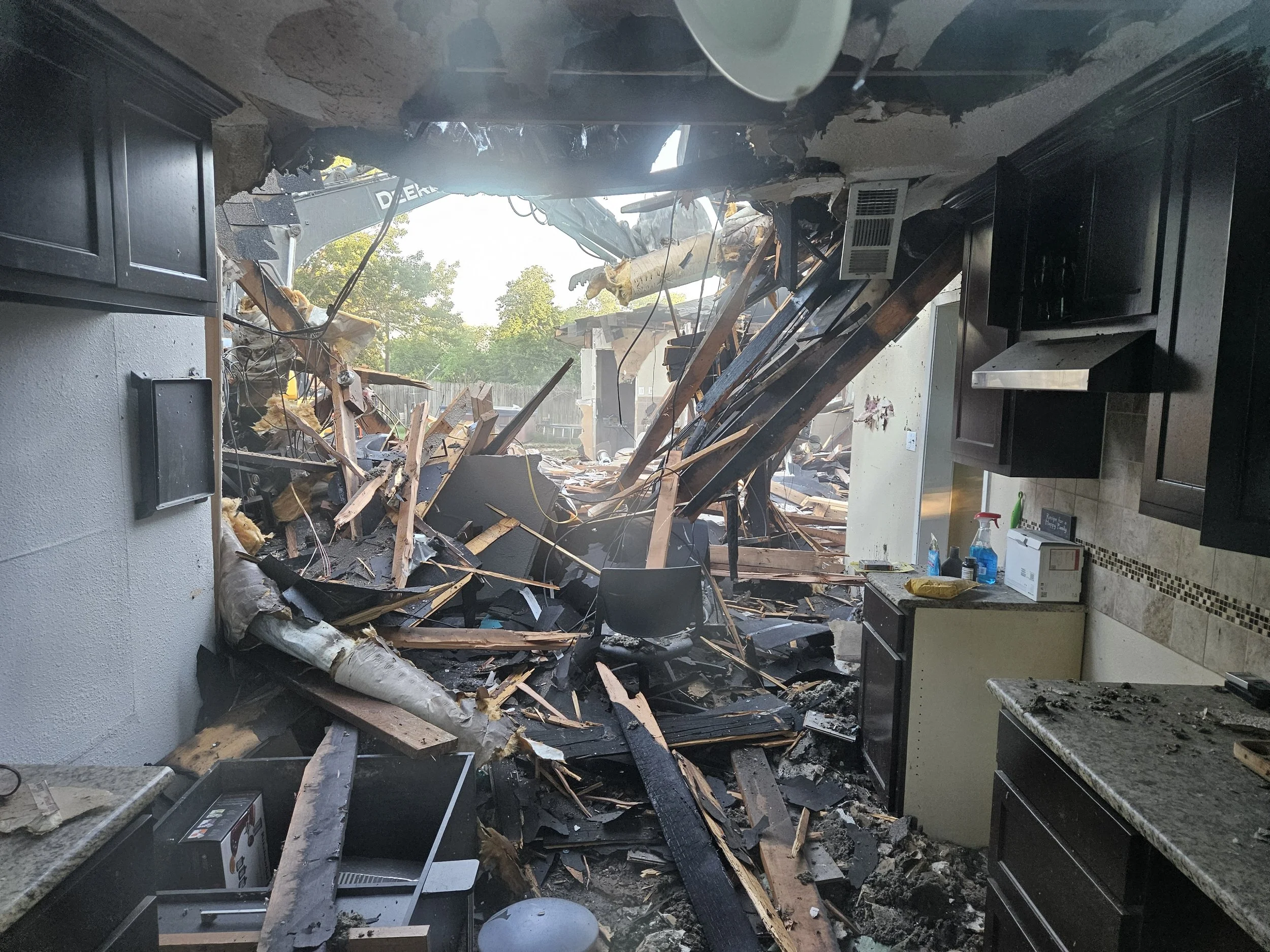 Interior of Wend (CEO) home with extensive damage due to fire. The Home is under demolition with Impervious Building and Design operating the heavy machinery.