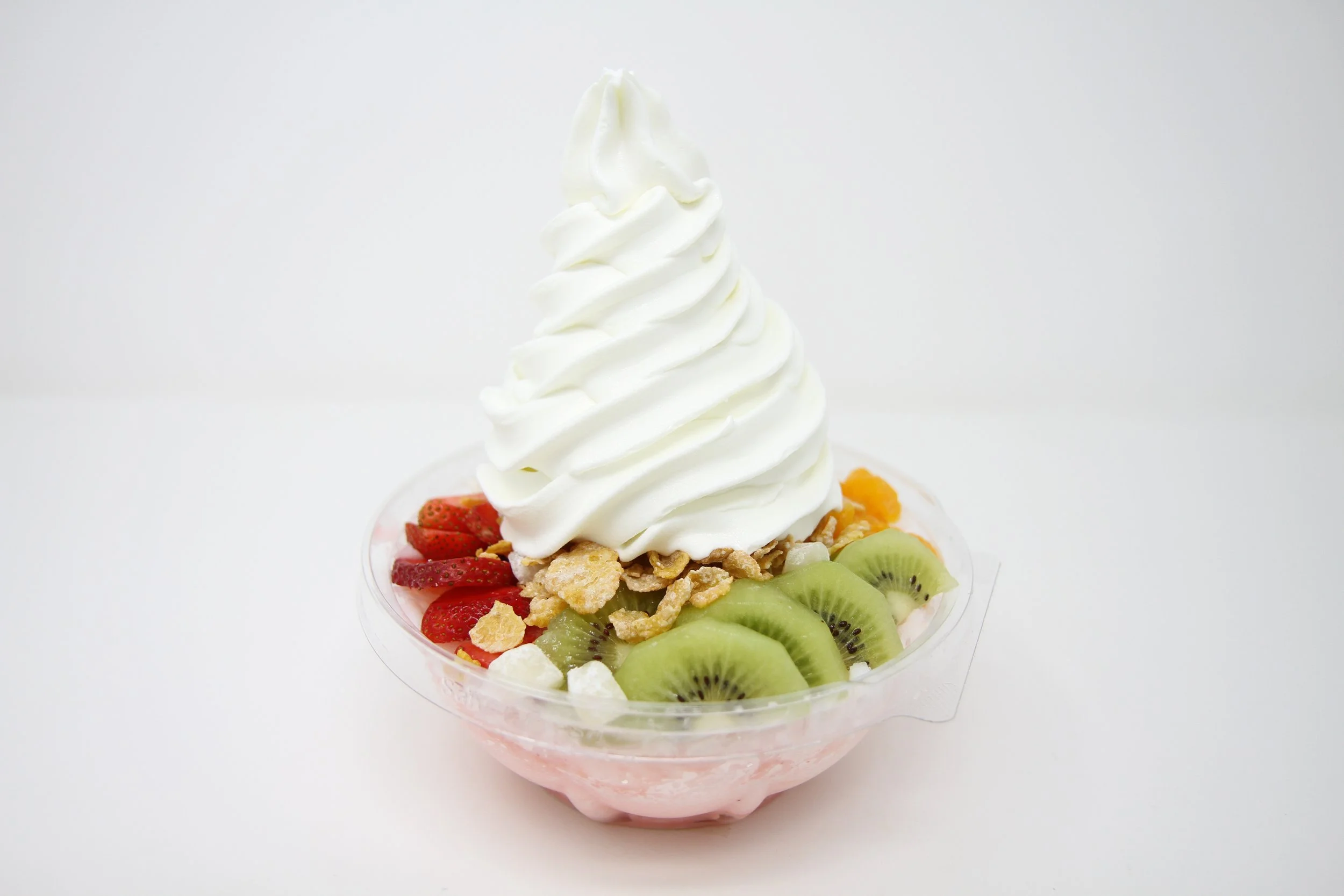 Breeze Yogurt Snow in clear bowl, layered with shaved milk ice, strawberry condense milk, fruits, mochi, cereal, and topped with in-house made frozen yogurt.