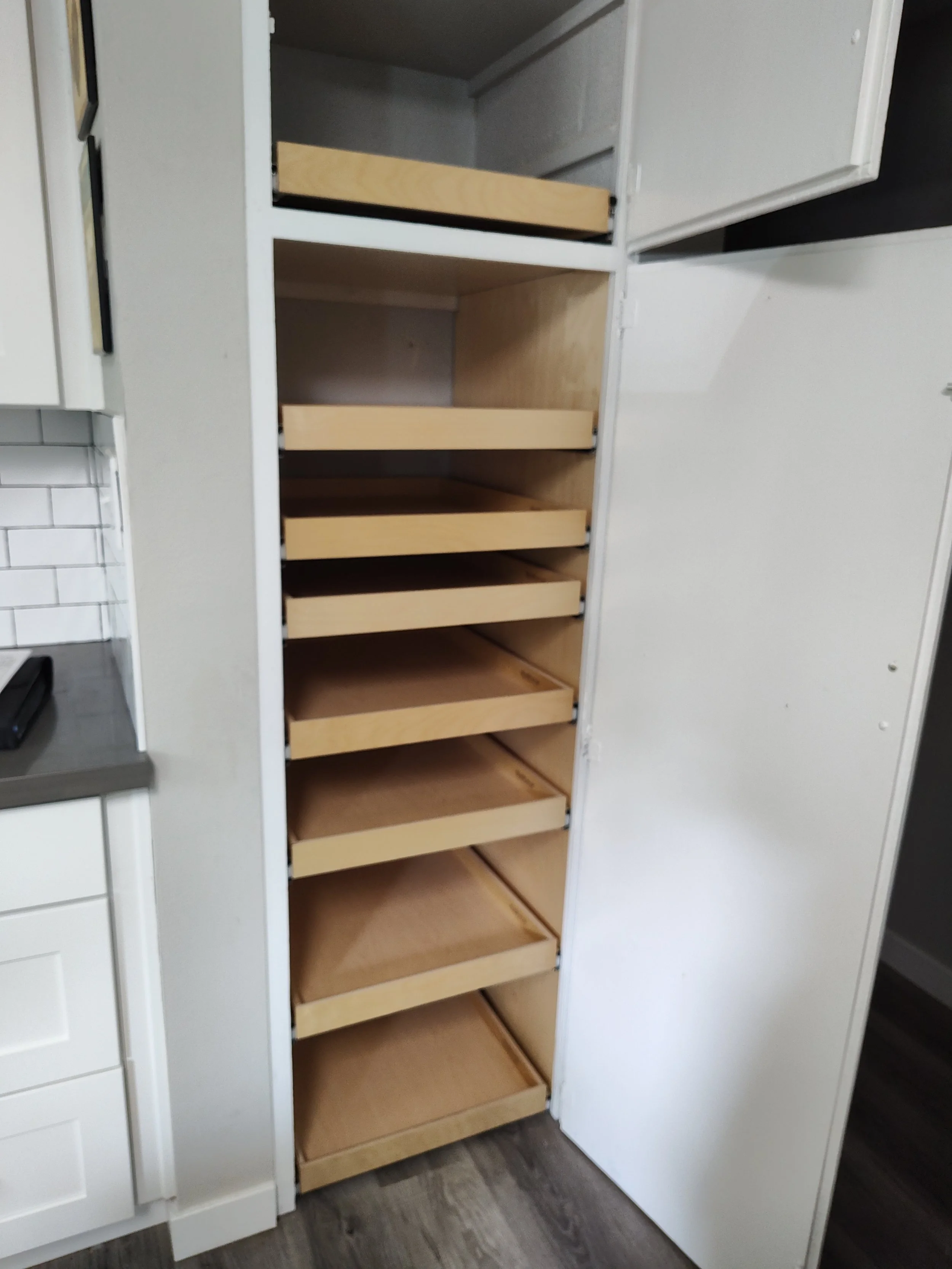 Empty kitchen pantry with open wooden shelves.