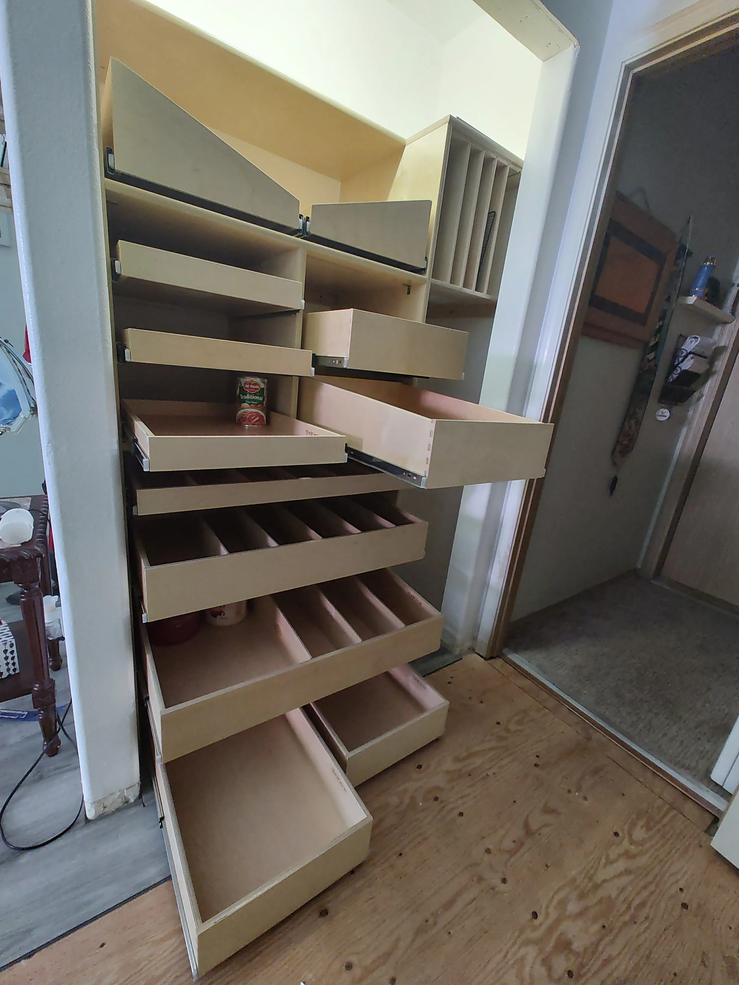 An empty wooden kitchen spice and drawer storage cabinet with multiple open drawers and compartments.