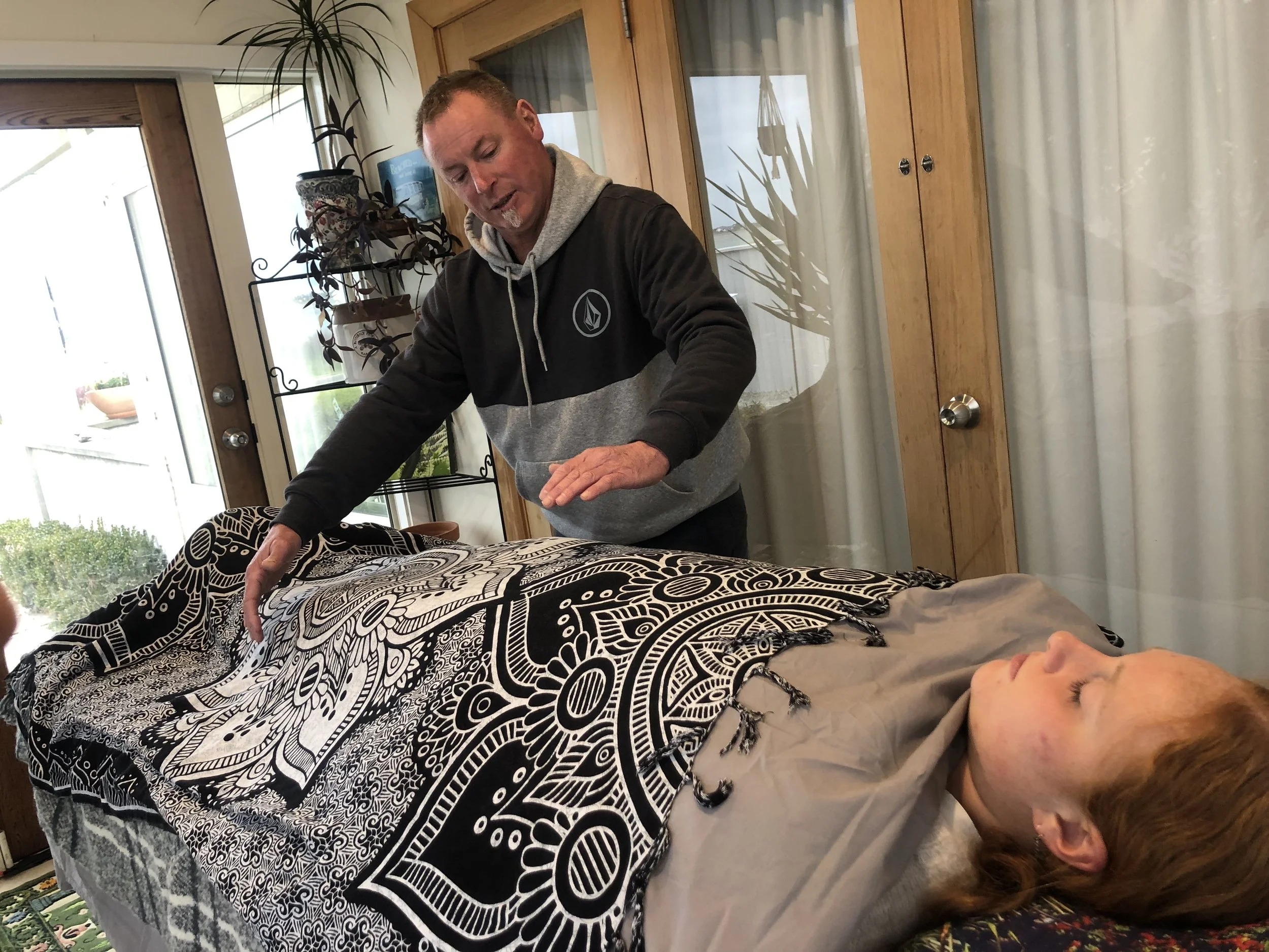 Energy healing practitioner Harley connecting through wairua and touch during a Honohono Healing treatment.