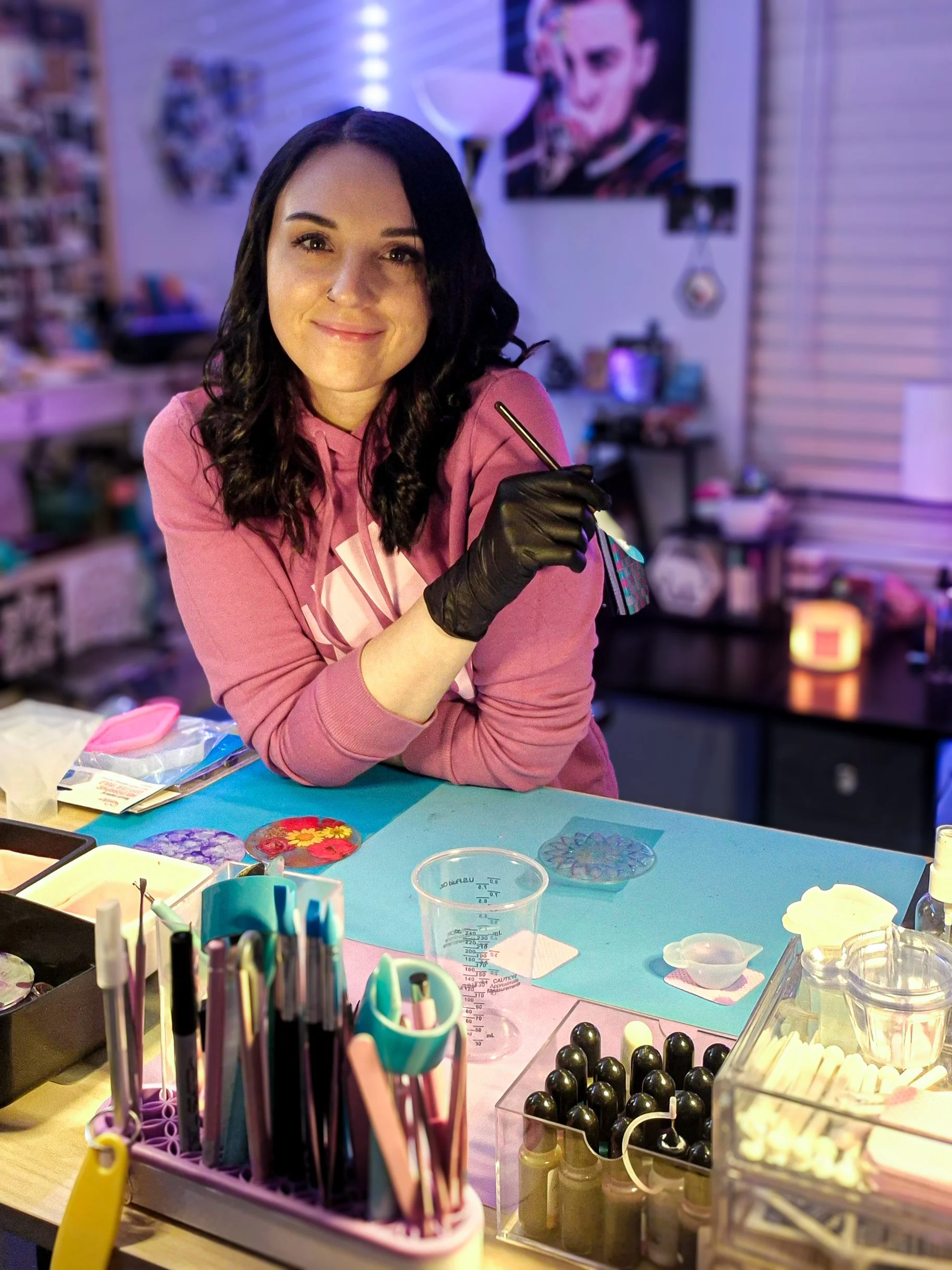 Ali, owner of Aliidecalii LLC, creating handmade resin art and stickers in her colorful studio workspace.