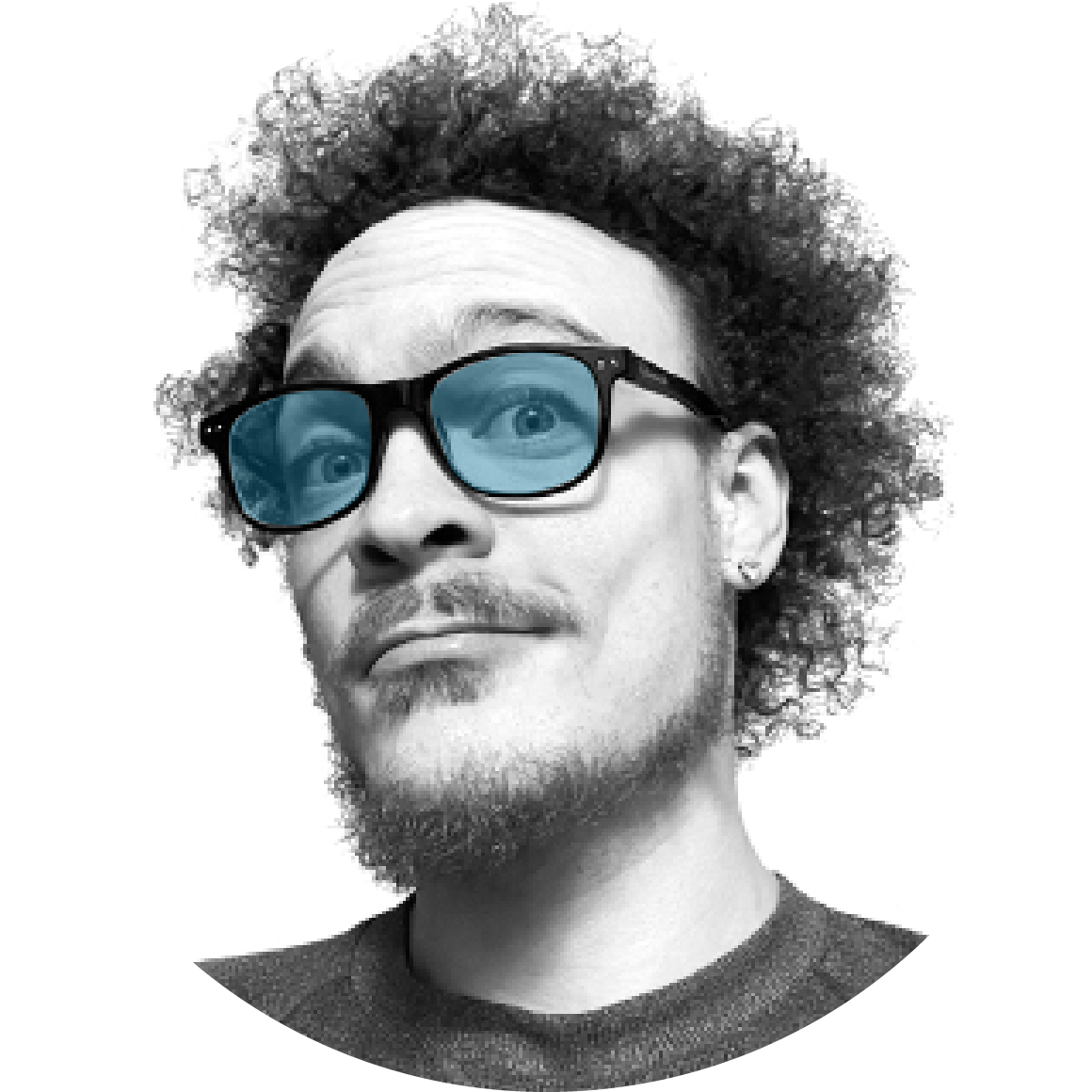 Black-and-white portrait of Artist and designer Juvian Duff with curly hair, wearing glasses with blue-tinted lenses, looking slightly to the side with a playful expression.