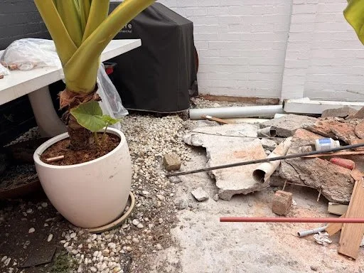Broken concrete, PVC piping, and rubble across the entire space