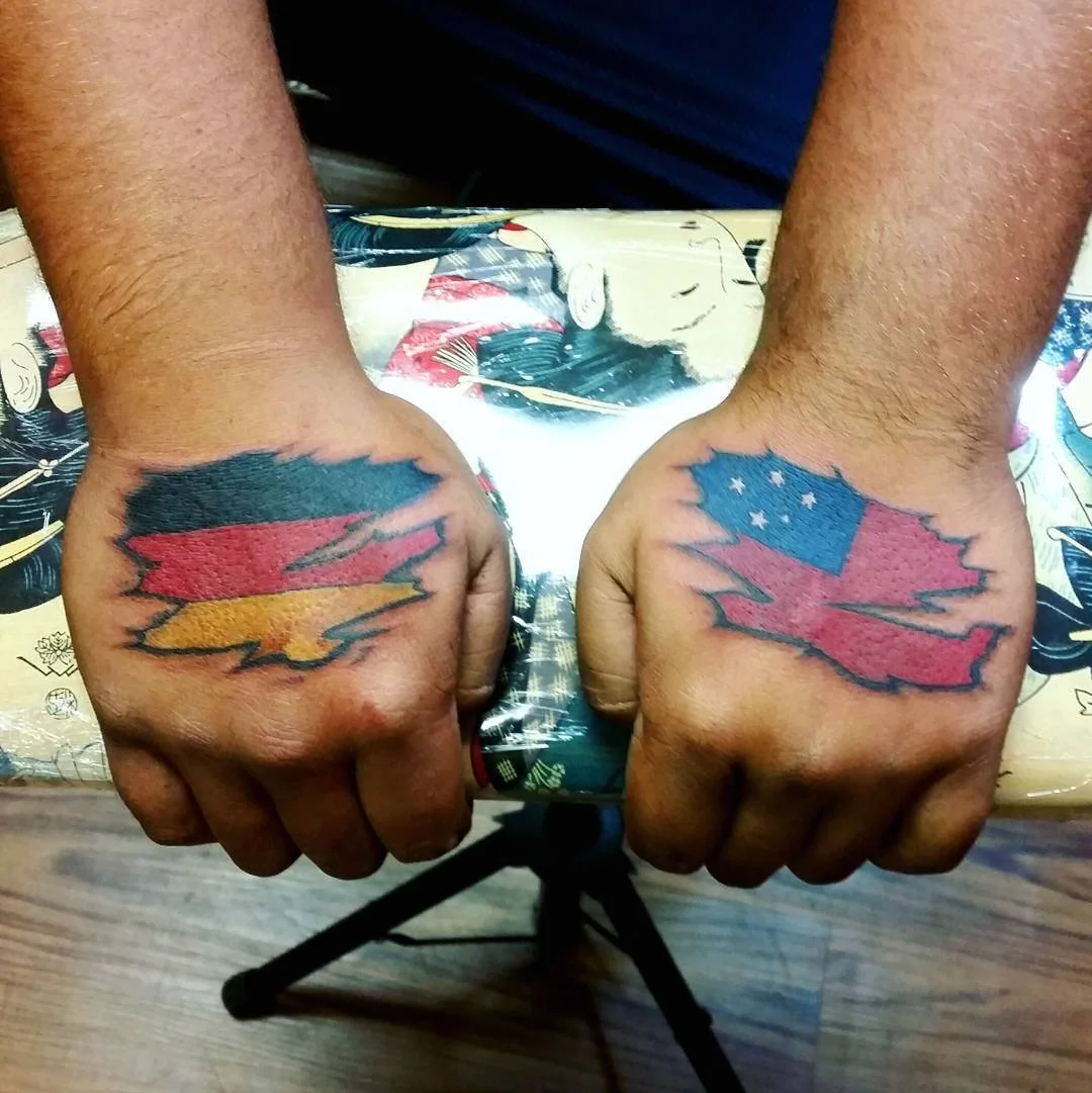 Two hands with matching tattoos of lightning bolts, one tattoo styled with the American flag, and the other with the flag of Germany.