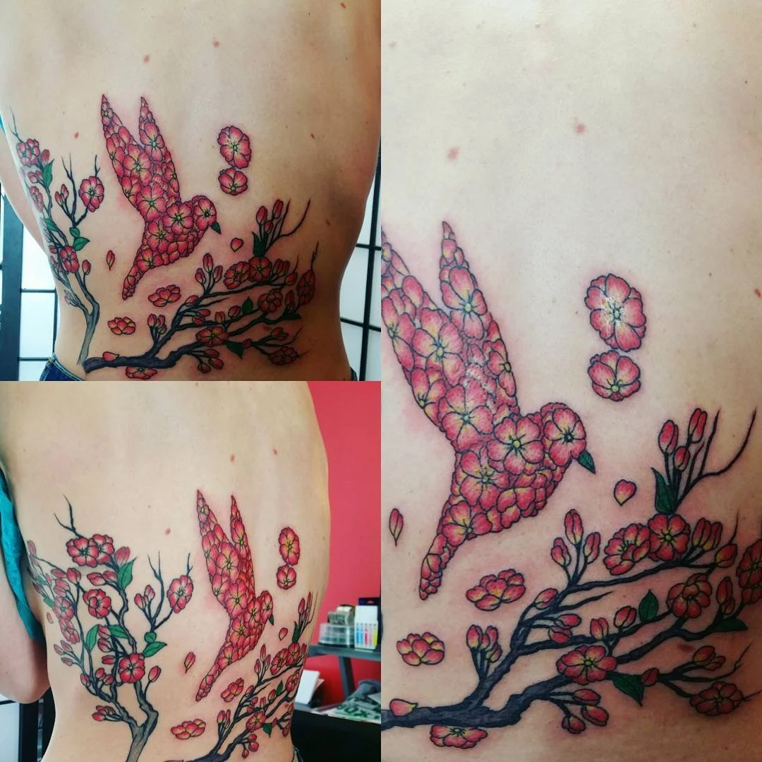 Colorful tattoo of a bird flying among cherry blossoms on a person's side and ribcage, shown from multiple angles.