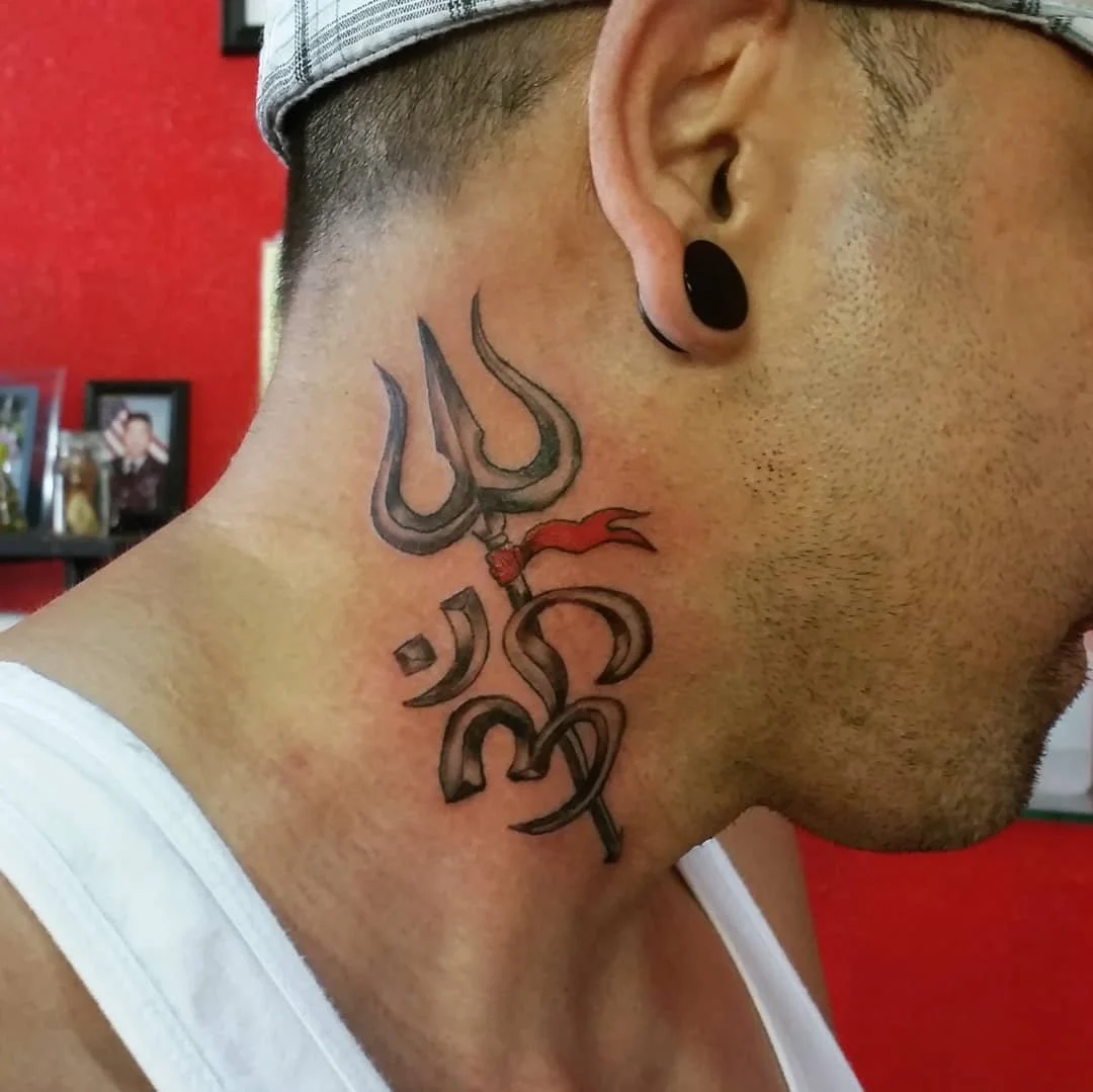 Tattoo of a trident and Sanskrit-style script on the side of a man's neck.