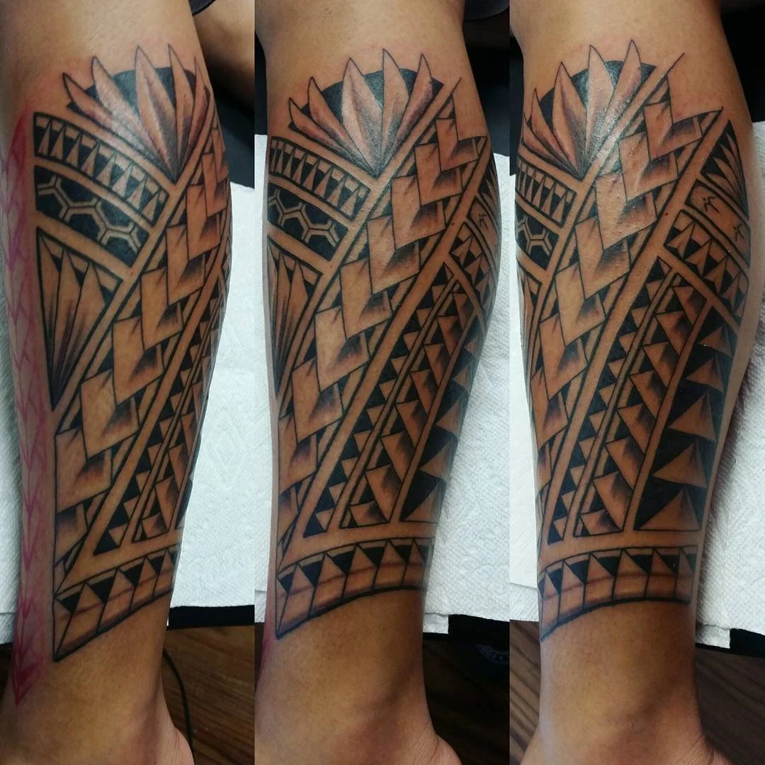 A geometric tribal-style tattoo on a person's forearm with black and gray shading.