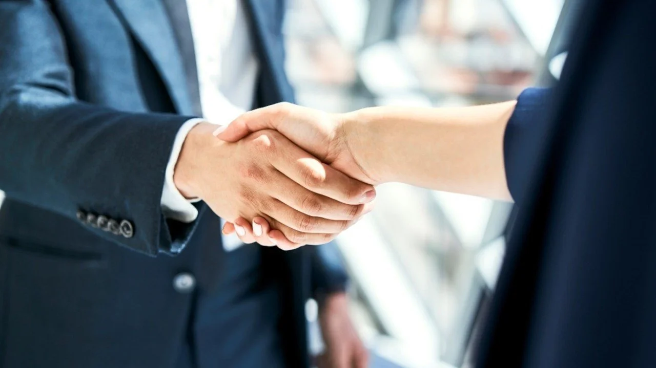 Two business leaders shaking hands after a successful mediation where they came to an agreement by mutual concession to meet their needs.