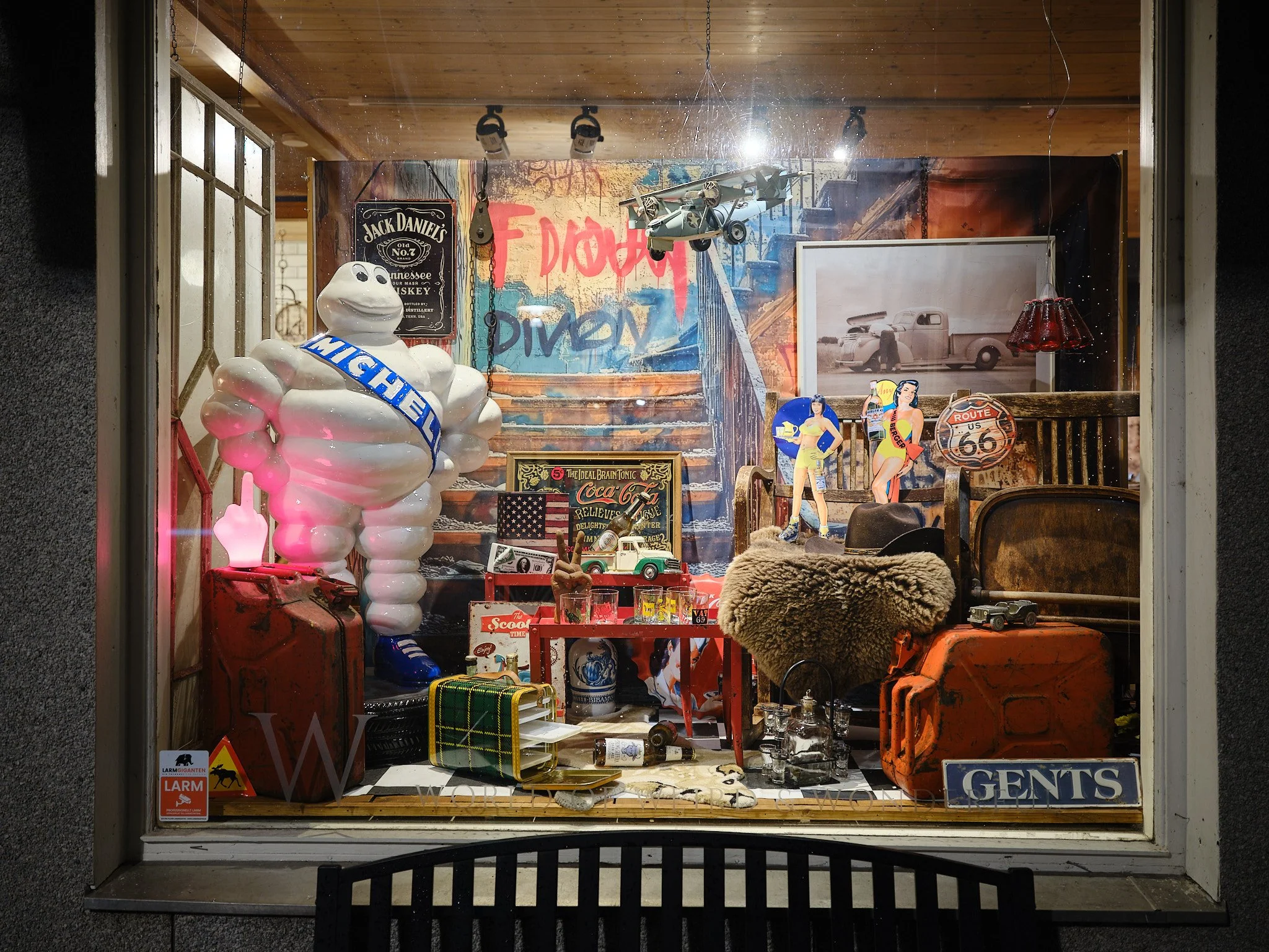 Ett skyltfönster med vintage-inredning, leksaker, memorabilia och en stor Michelin-gubbe.