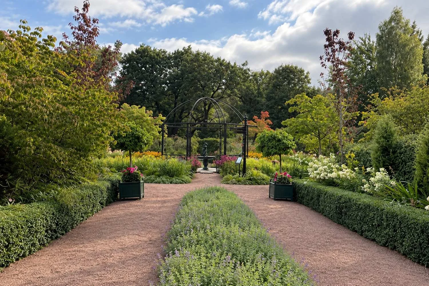 Jonsereds trädgårdar med grusgångar, planteringar och pergola – ett utflyktsmål i Jonsered med trädgård och café.