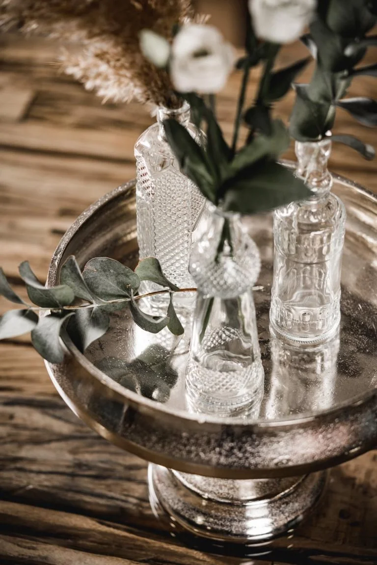 serveringsfat på fot i rå aluminium med glas och dekoration