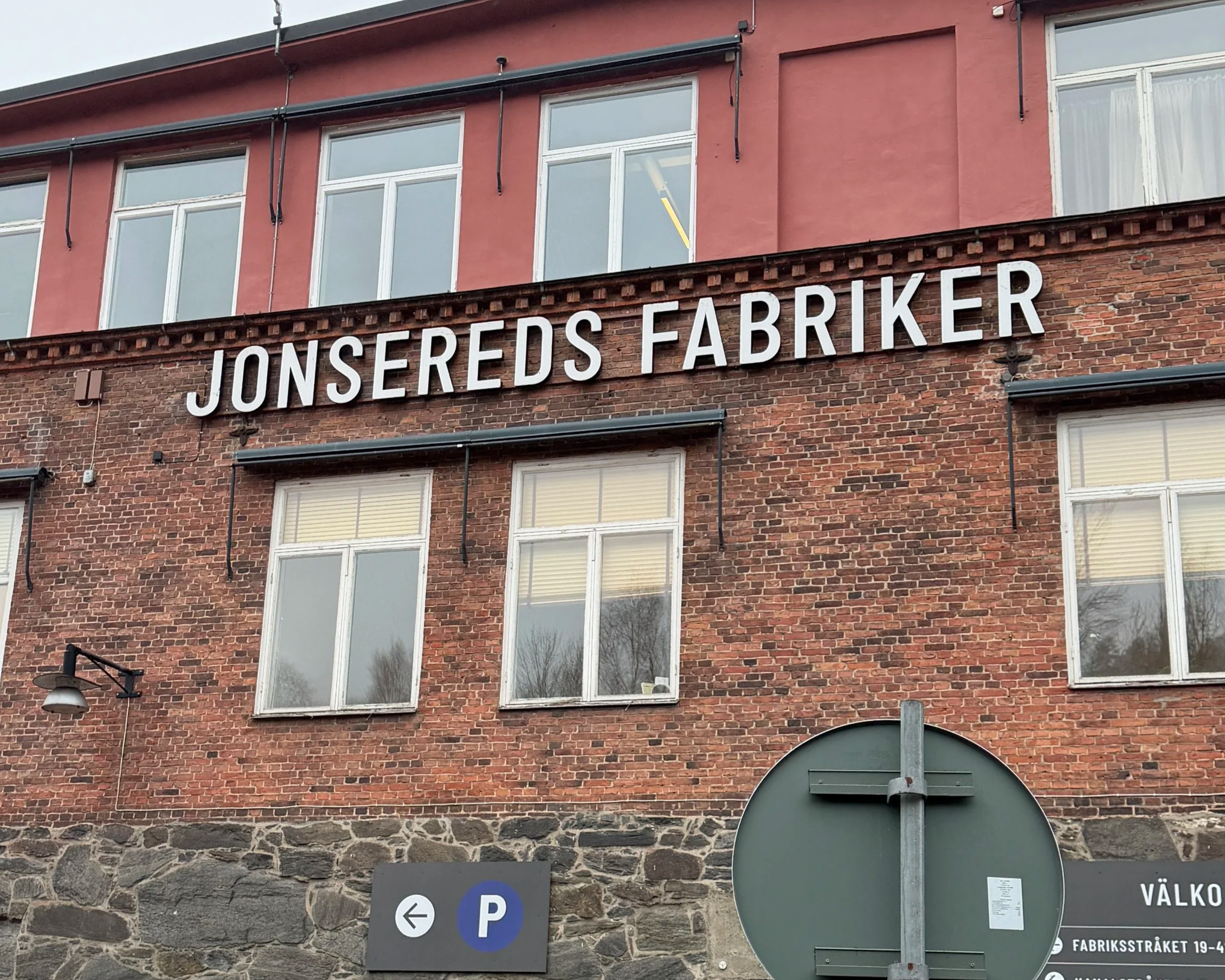 Jonsereds fabriker i Jonsered nära Göteborg med tegelbyggnad och skylt