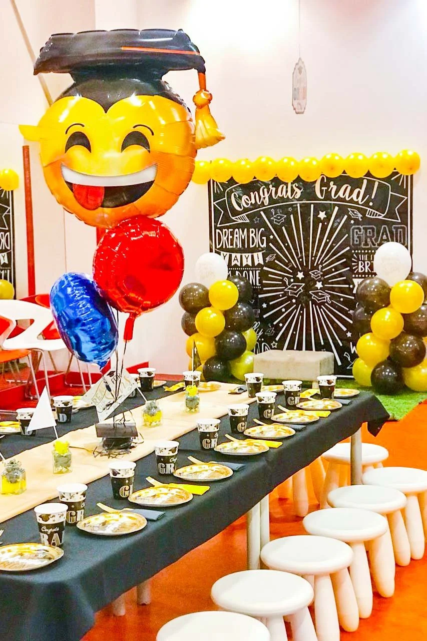 Graduation party celebration with balloons, a decorated table, and a chalkboard sign that says 'Congrats Grad'.