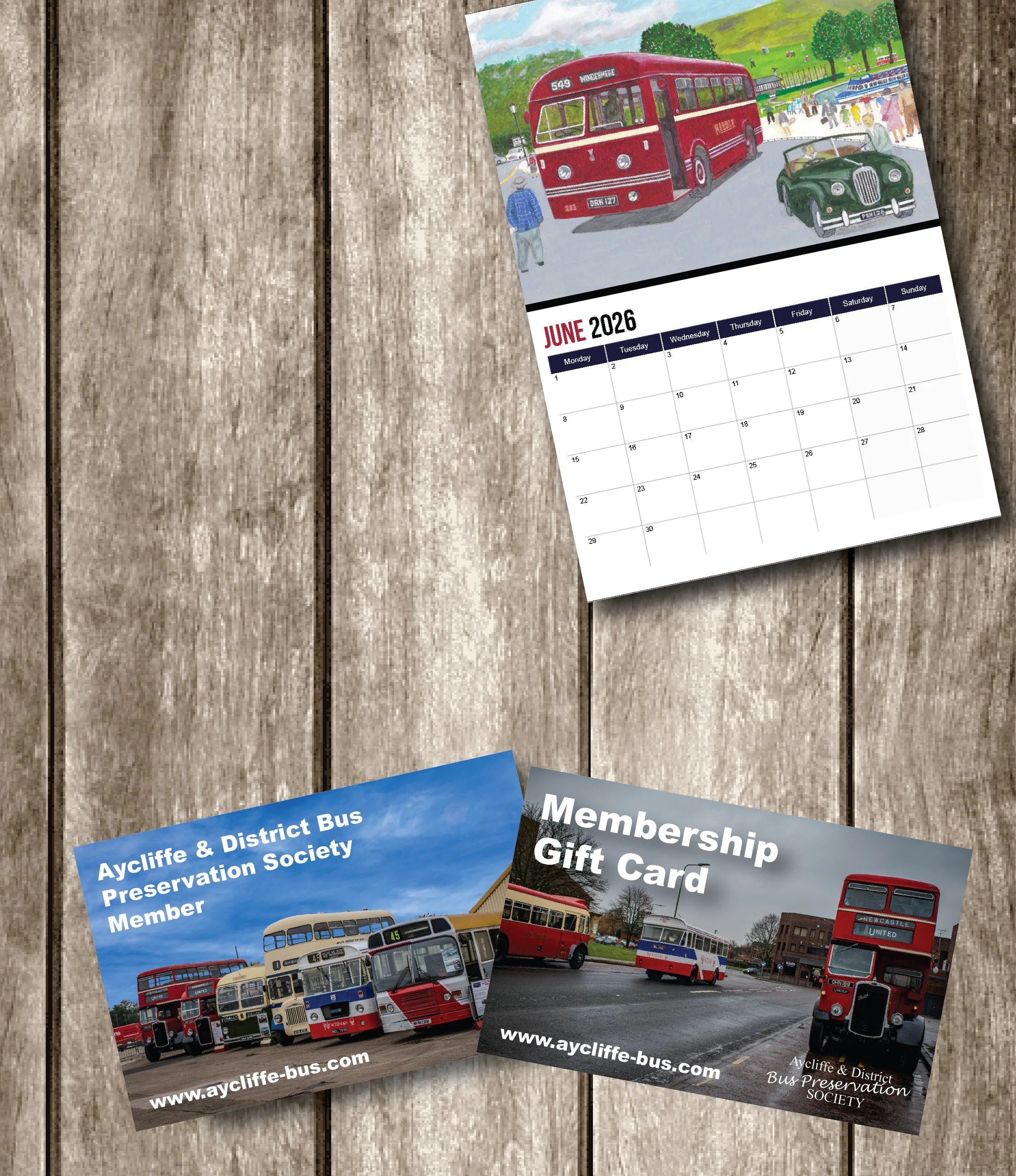A calendar page for June 2026 showing an illustration of vintage buses and a street scene with people and a red trolleybus, along with various bus society membership cards featuring vintage buses.