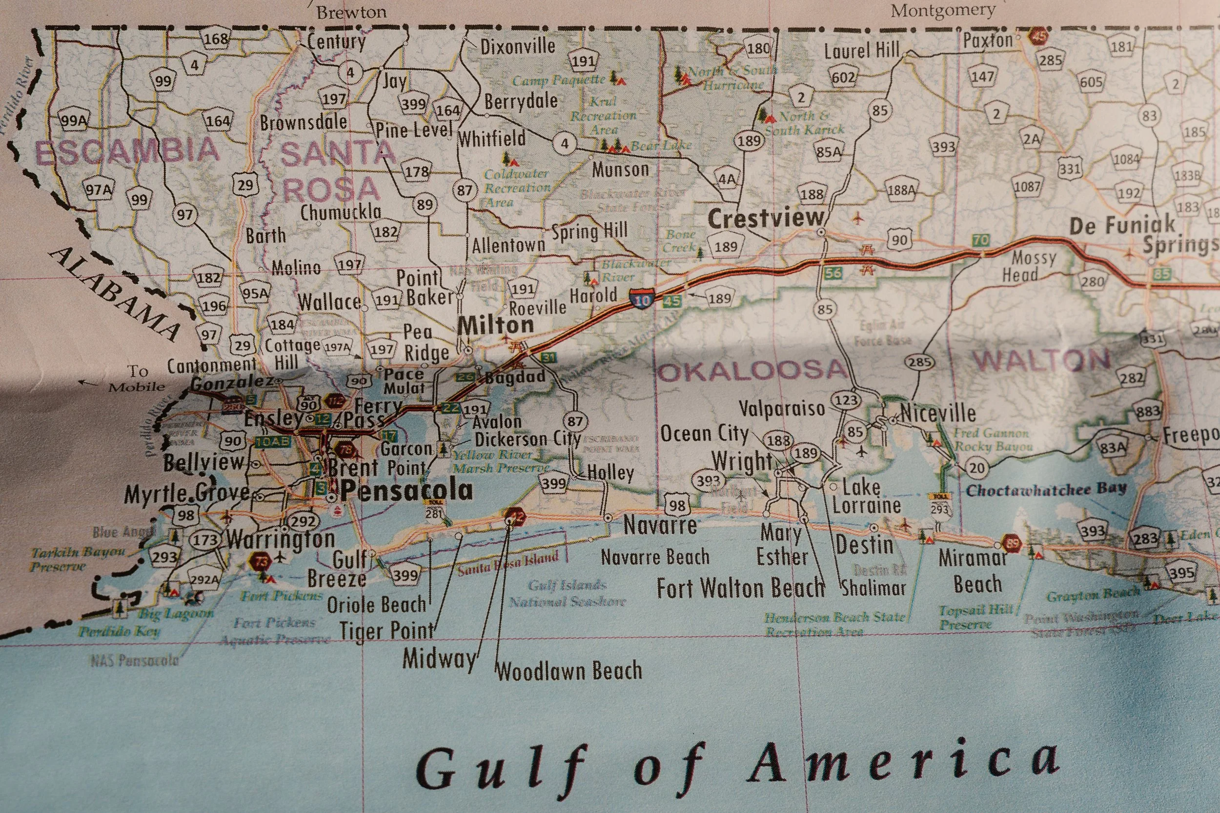 Close-up of a map showing part of the Gulf of Mexico and the northern coast of Florida, with cities like Pensacola, Milton, Crestview, and Crestview, and includes highways and recreational areas.