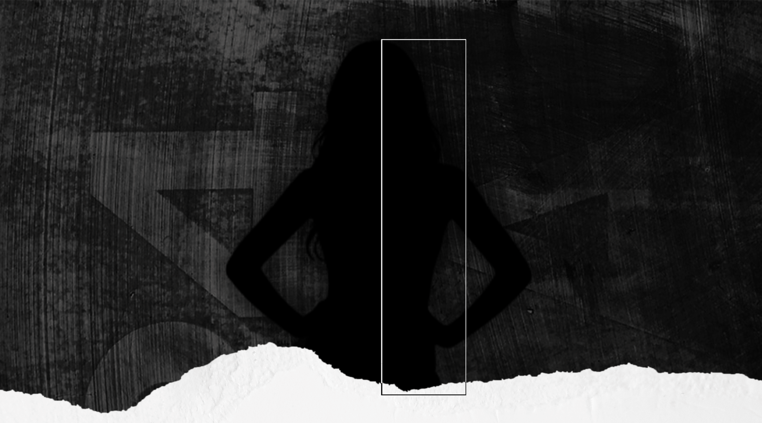 Silhouette d'une femme debout avec les mains sur les hanches, devant un mur sombre en béton.