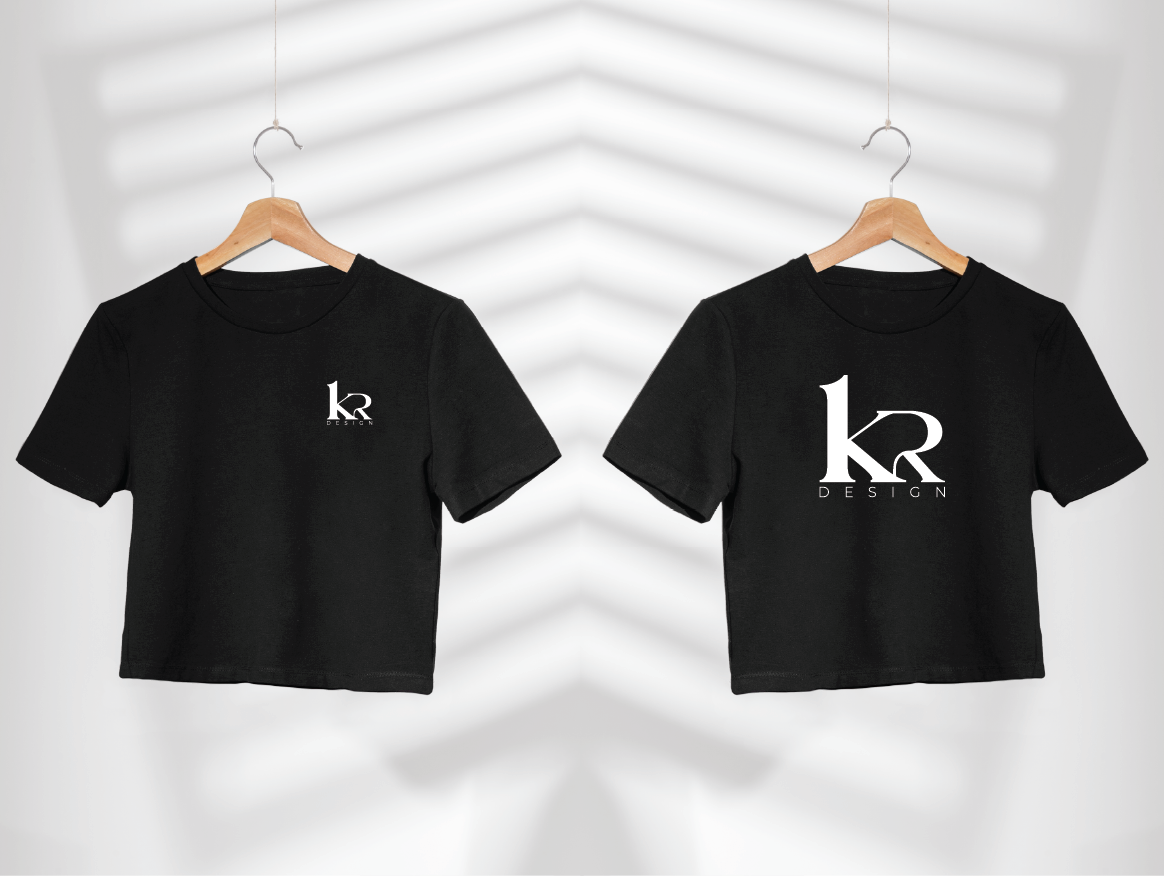 Two black T-shirts hanging on hangers, side by side, with white logo text that reads 'KR DESIGN' on the front and back.