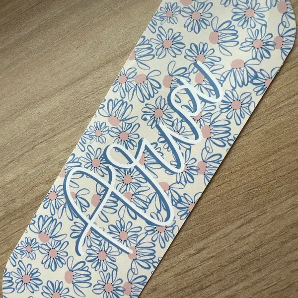 Aufkleber mit blumigem Design und dem Wort 'love' auf Holzoberfläche.