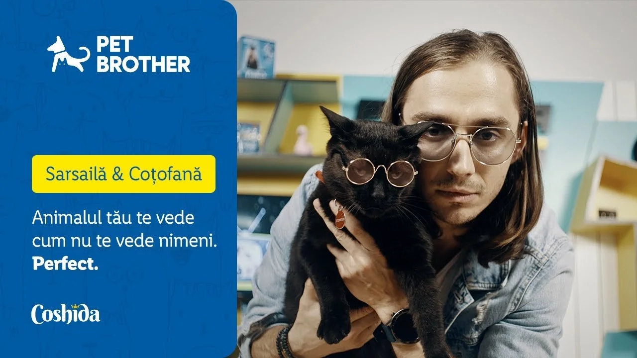 A man with long brown hair and glasses holding a black cat wearing glasses. The image includes a blue promotional overlay with the Pet Brother logo, Romanian text, and a Coshida logo.
