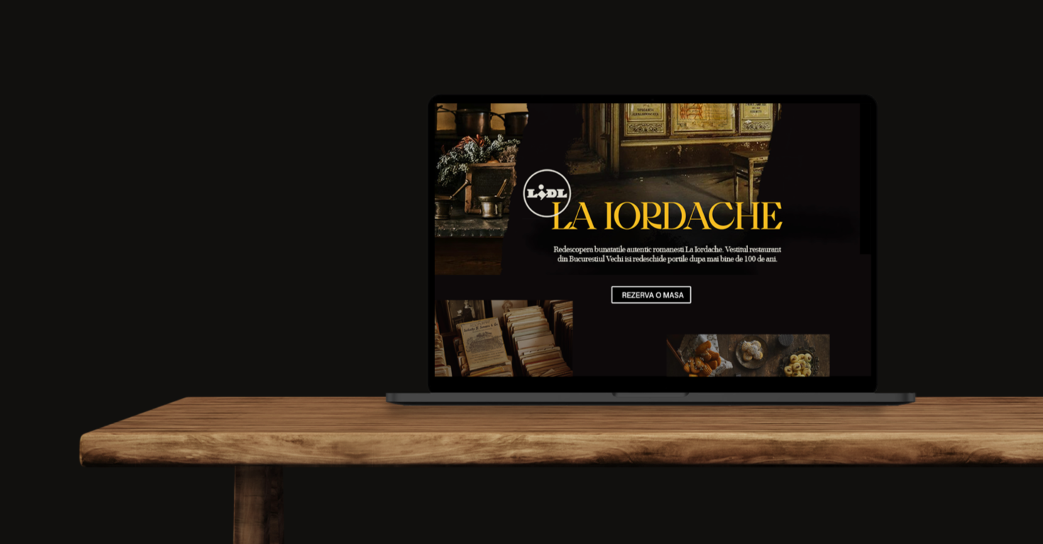 A laptop on a wooden table displaying a website for La Dordache, a restaurant specializing in authentic Romanian cuisine, with a black background.