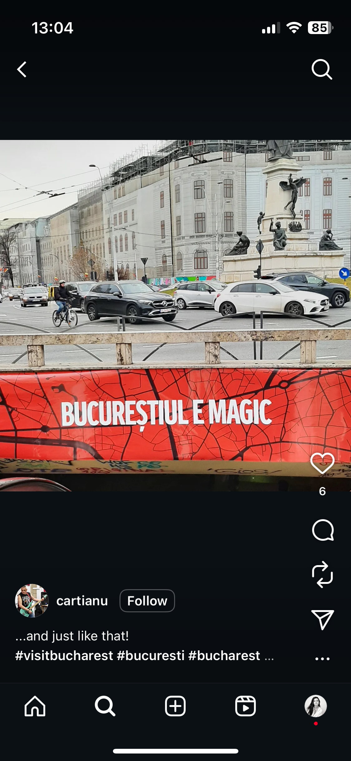 A street scene in Bucharest, Romania, with cars, a cyclist, and a monument featuring four statues and a winged figure, partially covered by a red sign with a city map pattern and the text "Bucureştiul e Magic."
