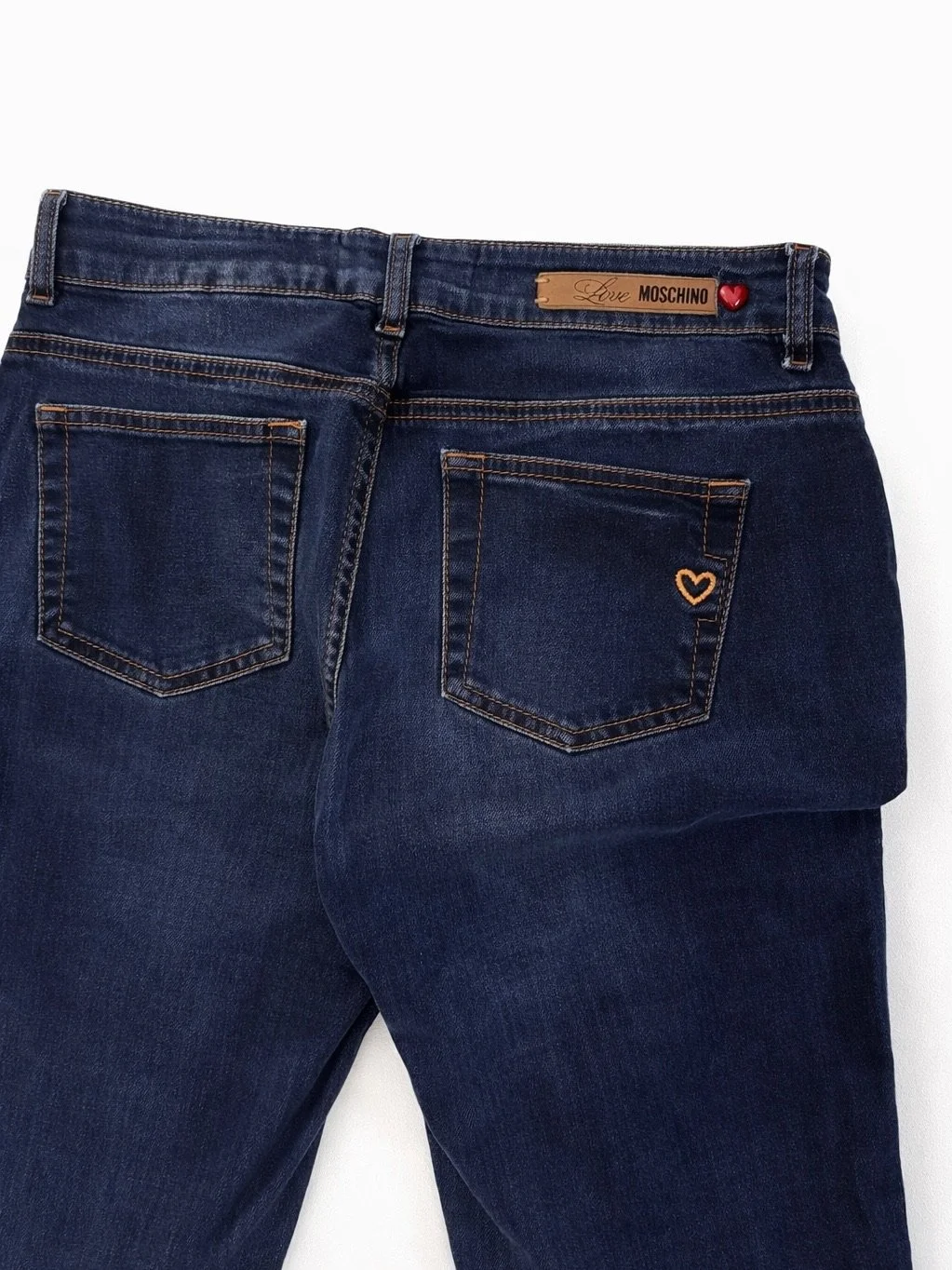 Close-up of Love Moschino dark wash jeans with gold hardware and logo details