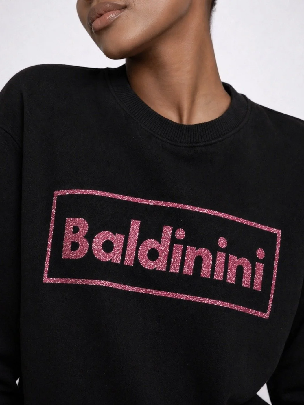 Close-up of Baldinini black sweatshirt with pink glitter logo print