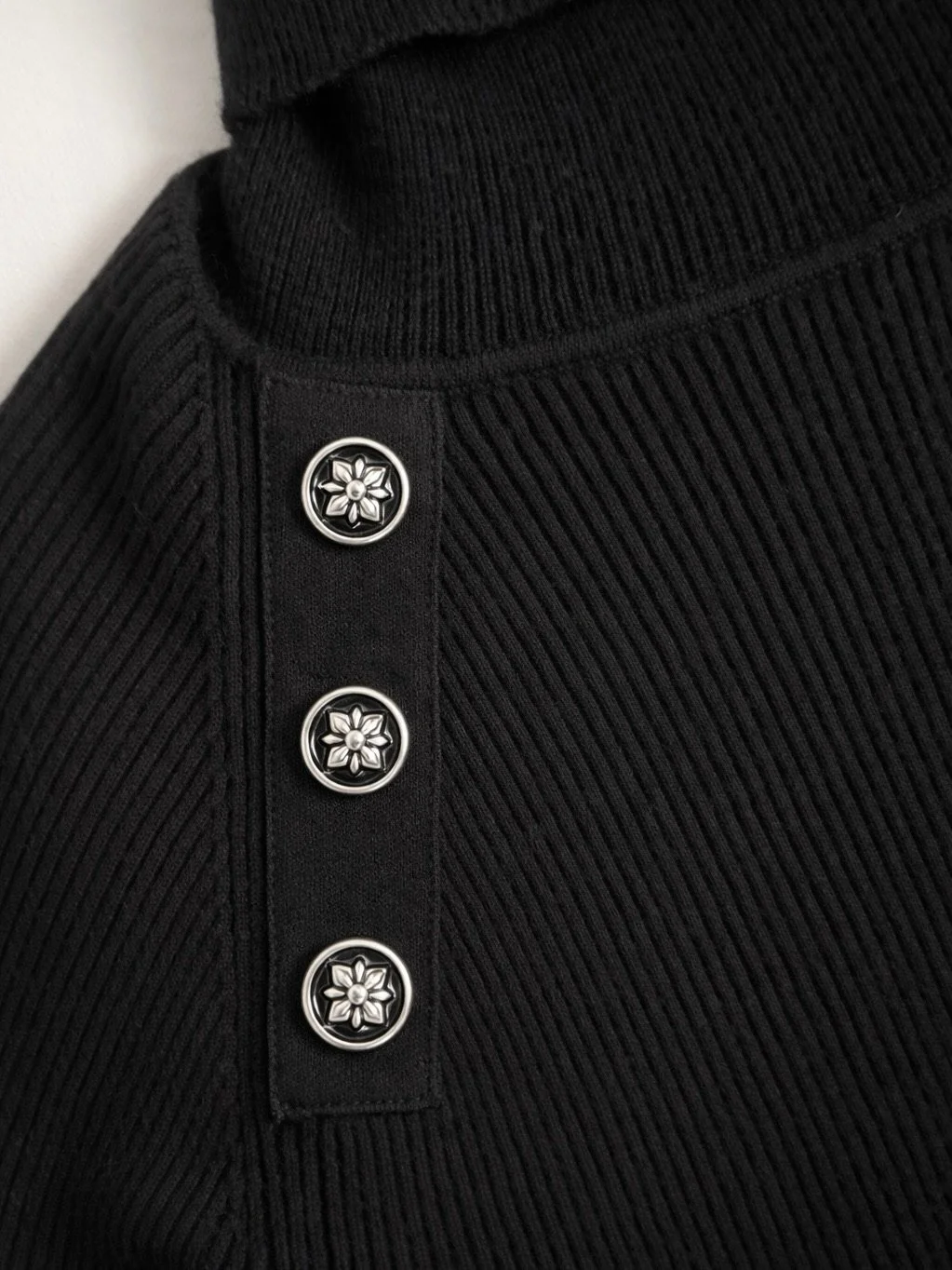 John Richmond black designer turtleneck silver-tone floral button shoulder detail close-up