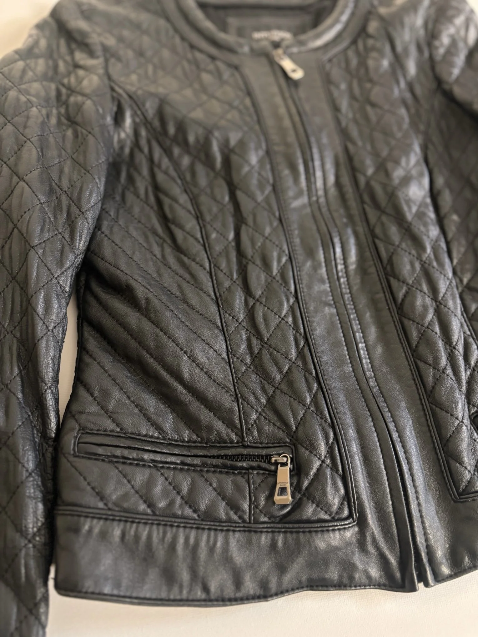 Intuition Paris black quilted leather jacket front detail with silver zip pocket and fitted silhouette