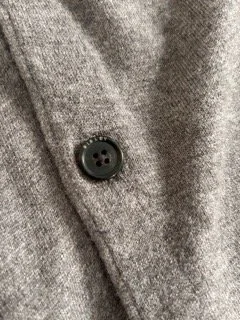 Close-up of Sisley branded cardigan button detail