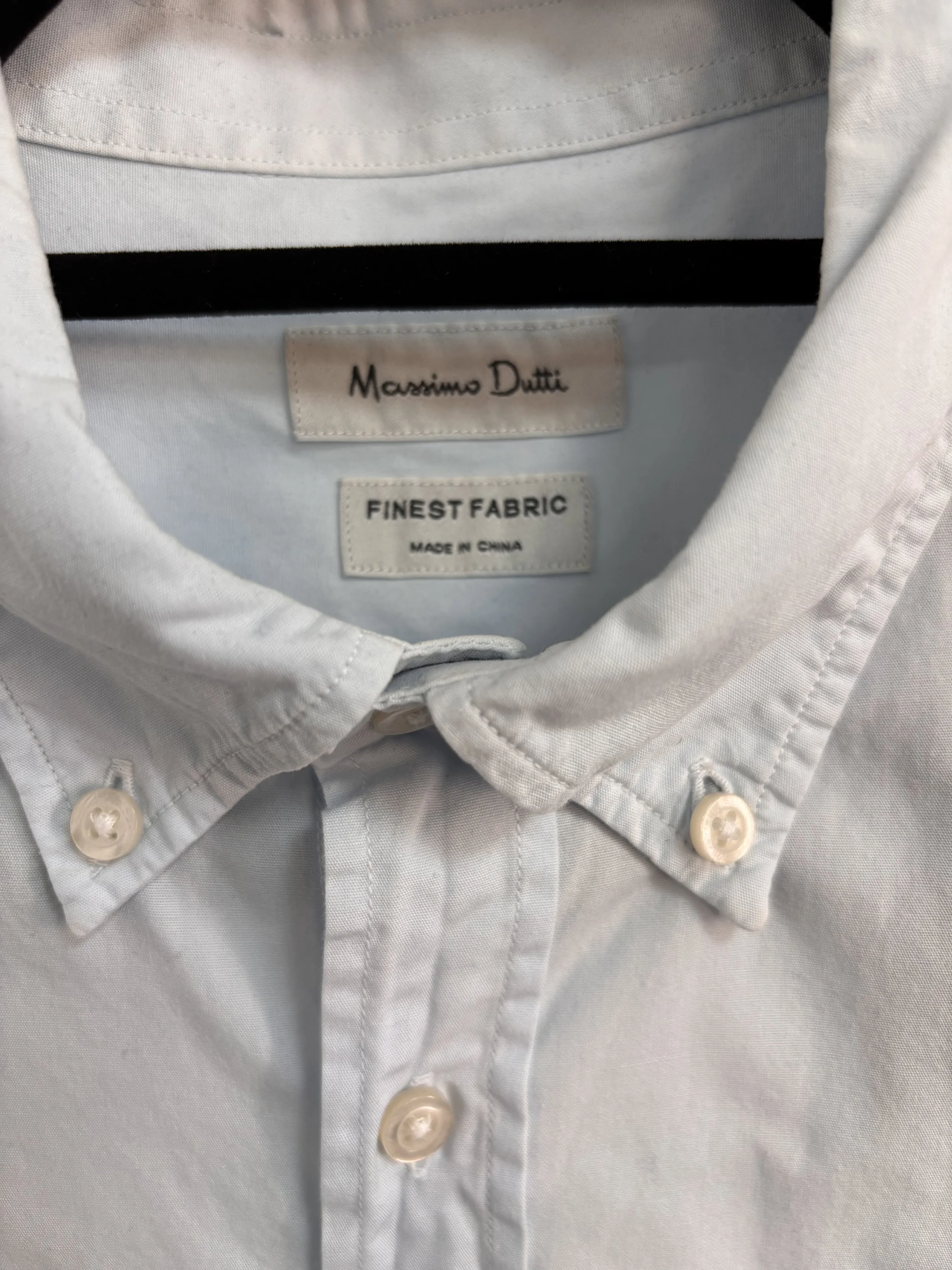 Folded Massimo Dutti light blue button-down shirt with classic collar and premium cotton fabric