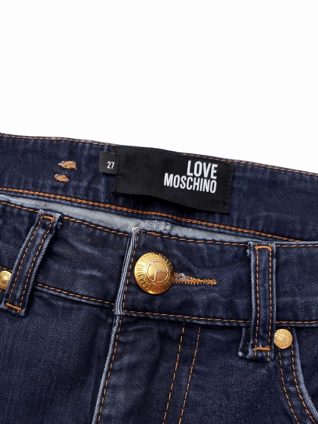 Close-up of Love Moschino dark blue designer jeans with gold logo button and signature branding detail
