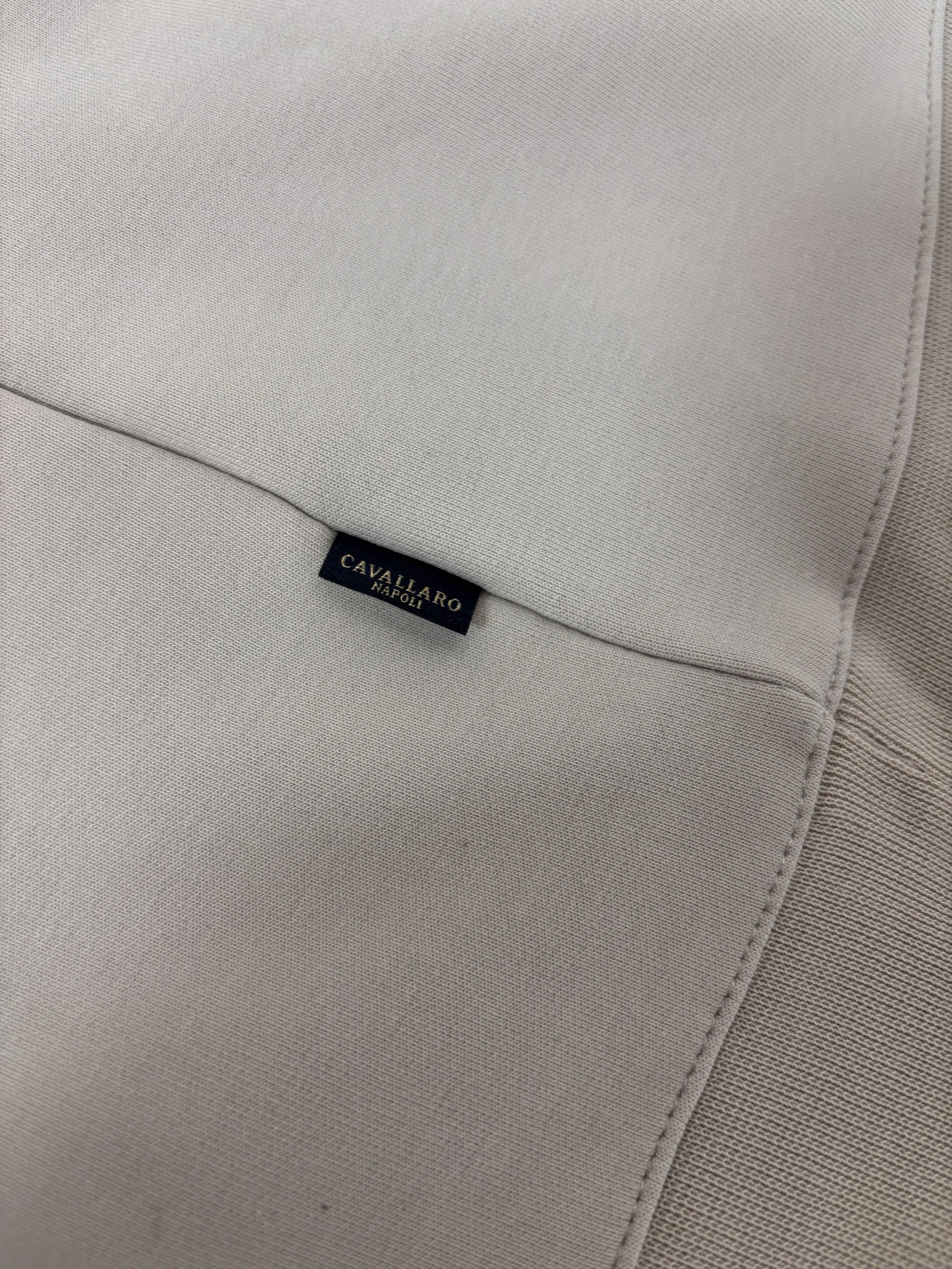 Close-up of Cavallaro Napoli signature woven logo tab on a cream beige luxury sweatshirt with premium minimalist design.