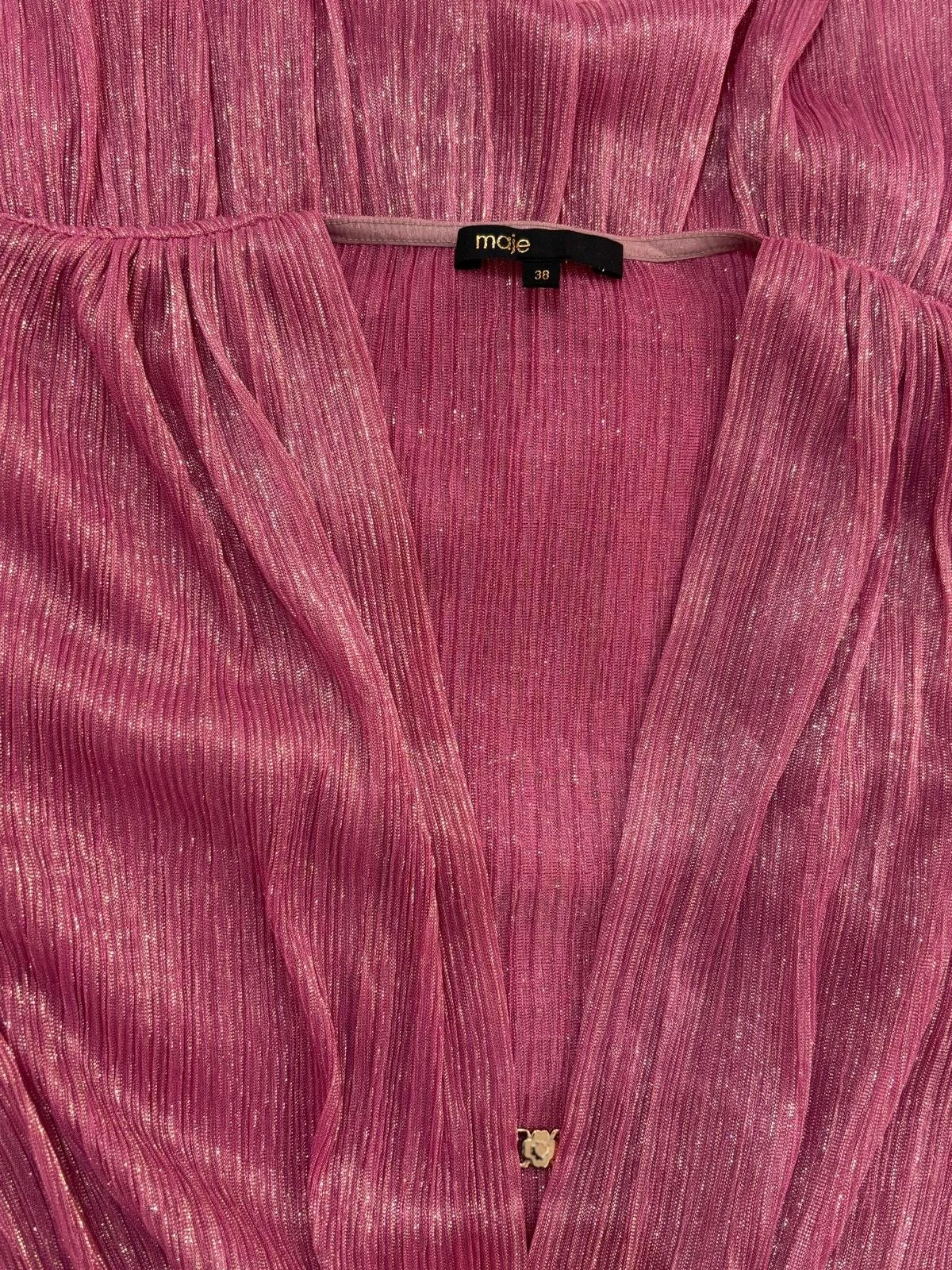 Close-up of Maje pink dress fabric with subtle gold-thread shimmer and V-neck detail, women’s designer dress.