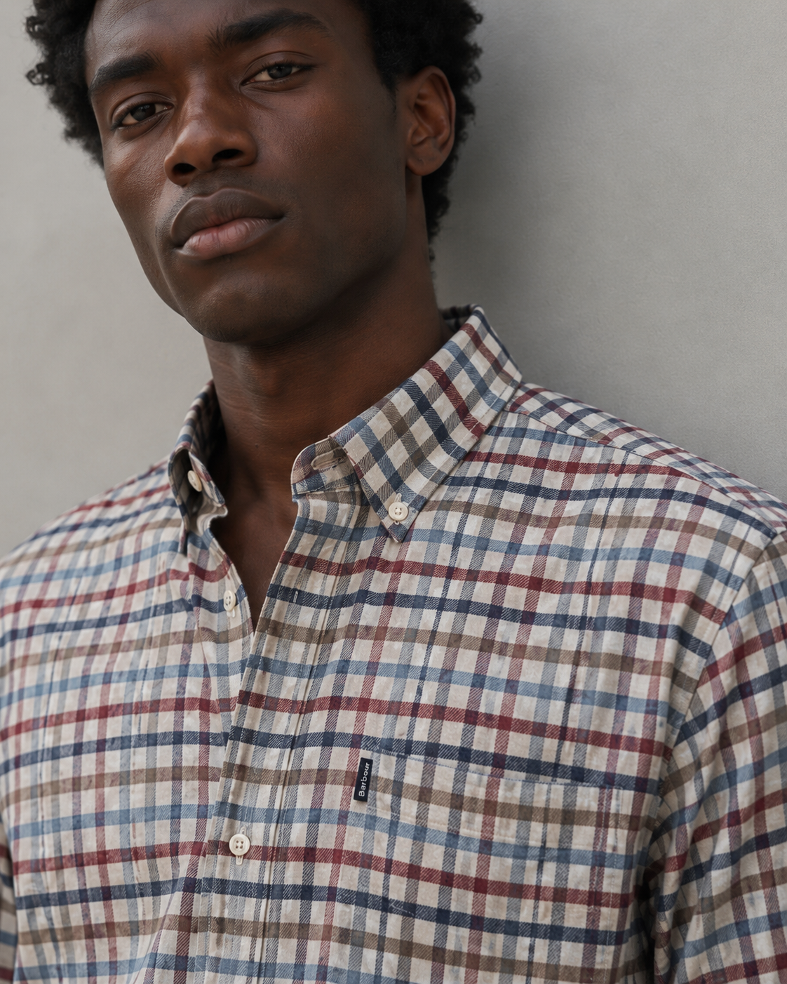Close-up of Barbour men’s checked cotton shirt featuring button-down collar, premium fabric texture and signature chest logo.